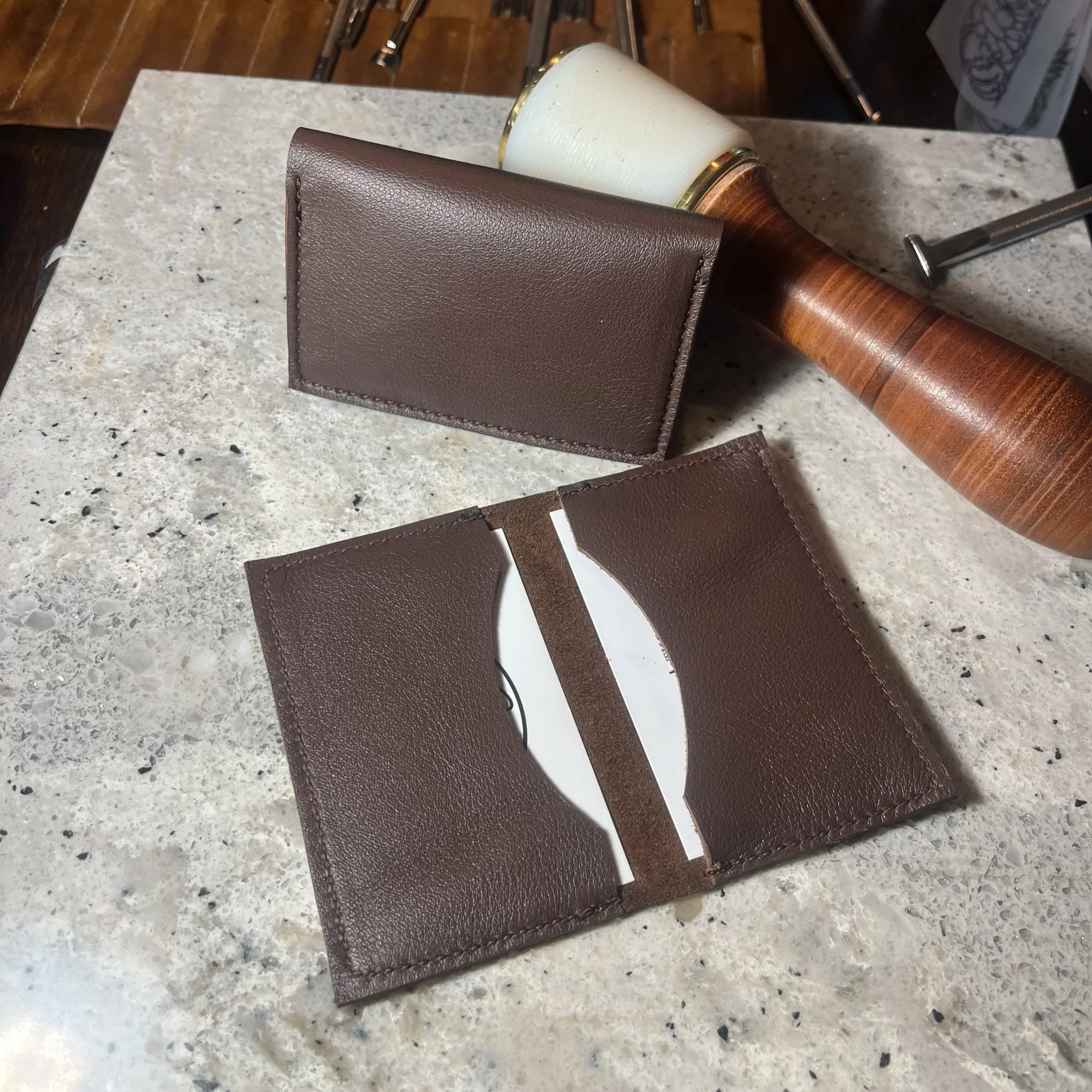 Close-up image of various leather swatches and a coffee cup on a speckled countertop.