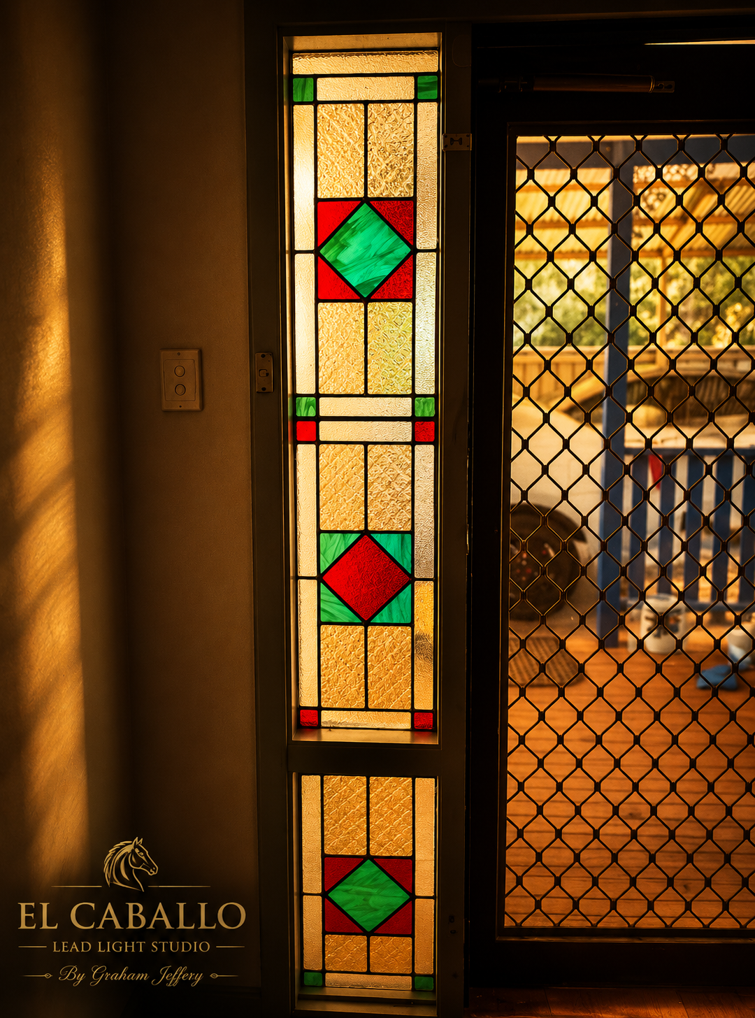 Colorful stained glass window with geometric patterns in red, green, and yellow, illuminated by sunlight.