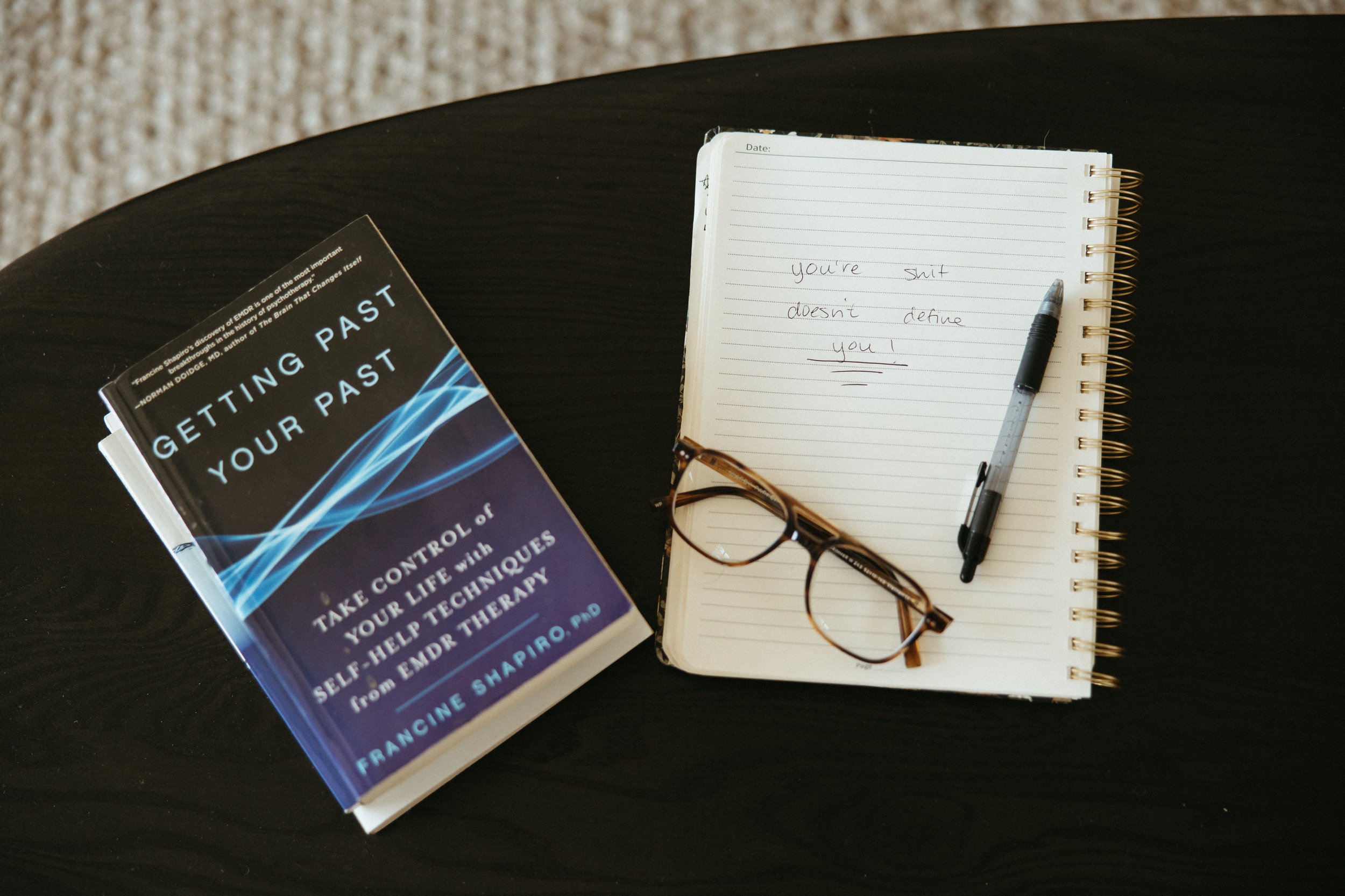Glasses and therapy book for Ketamine Assisted Therapy PA