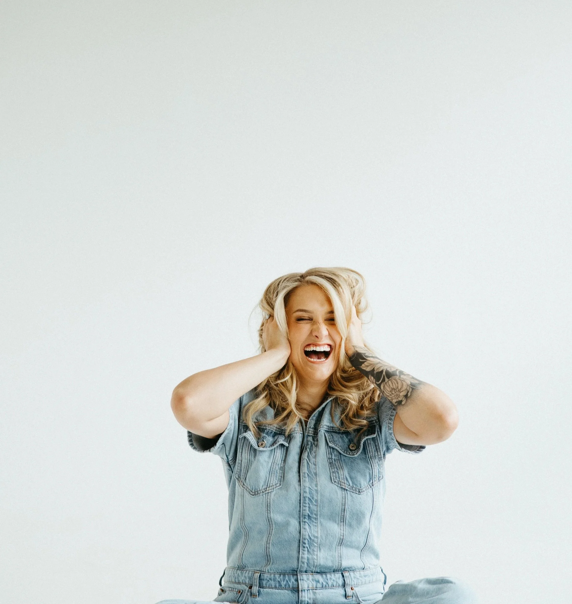 Woman smiling and tousling her hair, representing healing through trauma therapy and EMDR therapy in Pennsylvania and Colorado.