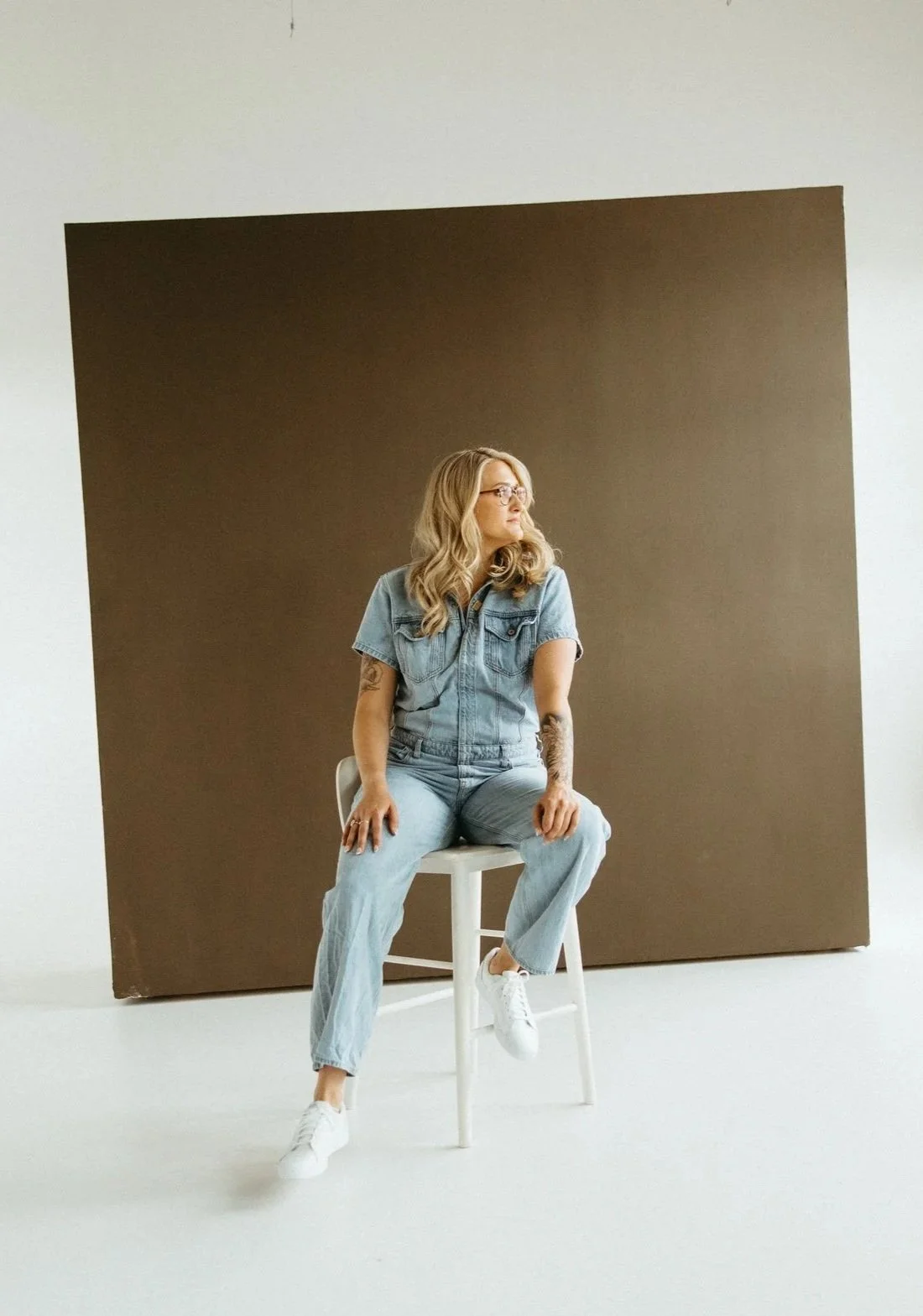Online Trauma therapist sitting on stool looking to the side in PA.