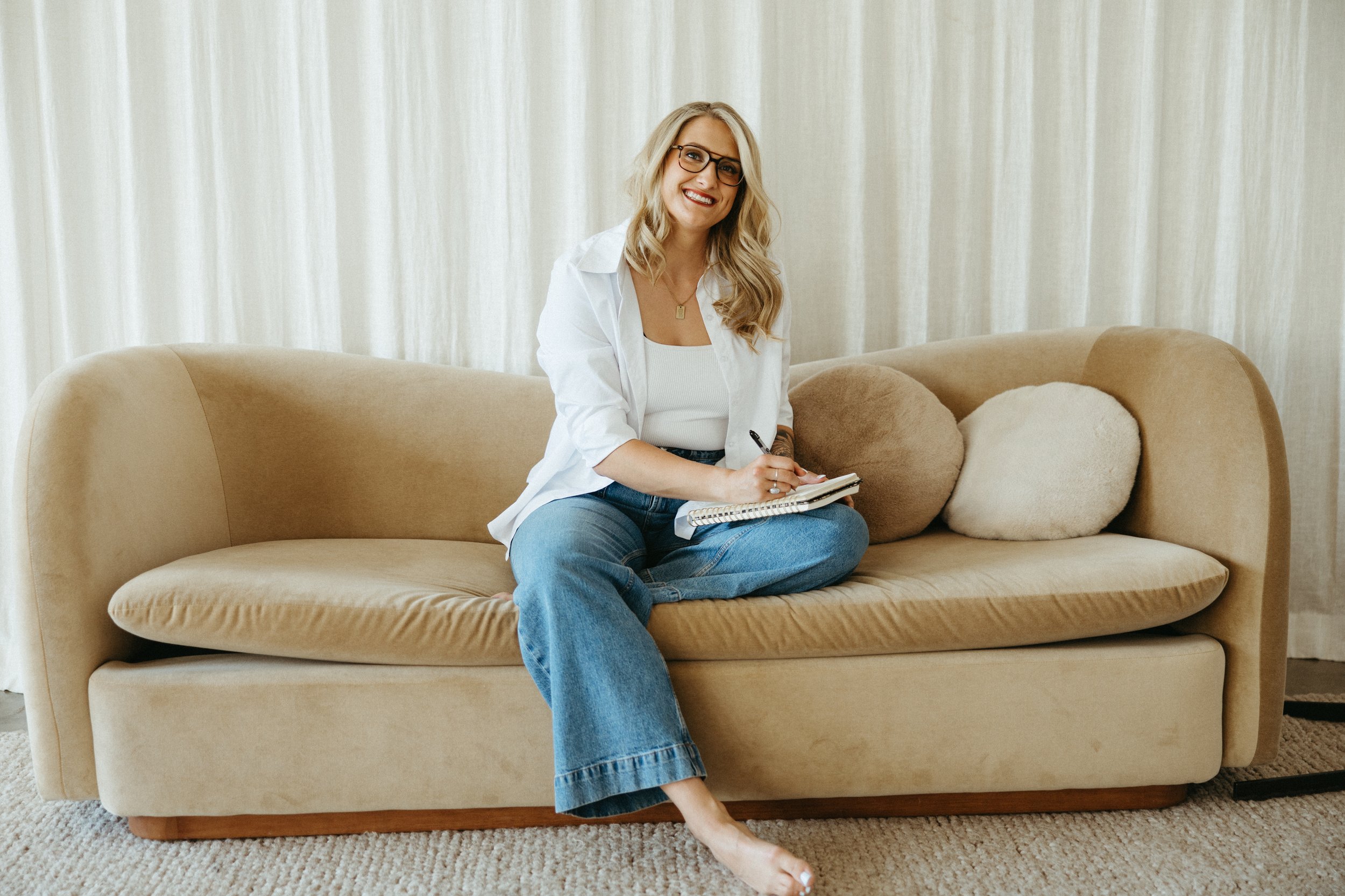 Hannah Guy, owner of Revive Therapy Services, writes in a journal as part of a reflective therapeutic practice focused on anxiety, self-awareness, and emotional healing.