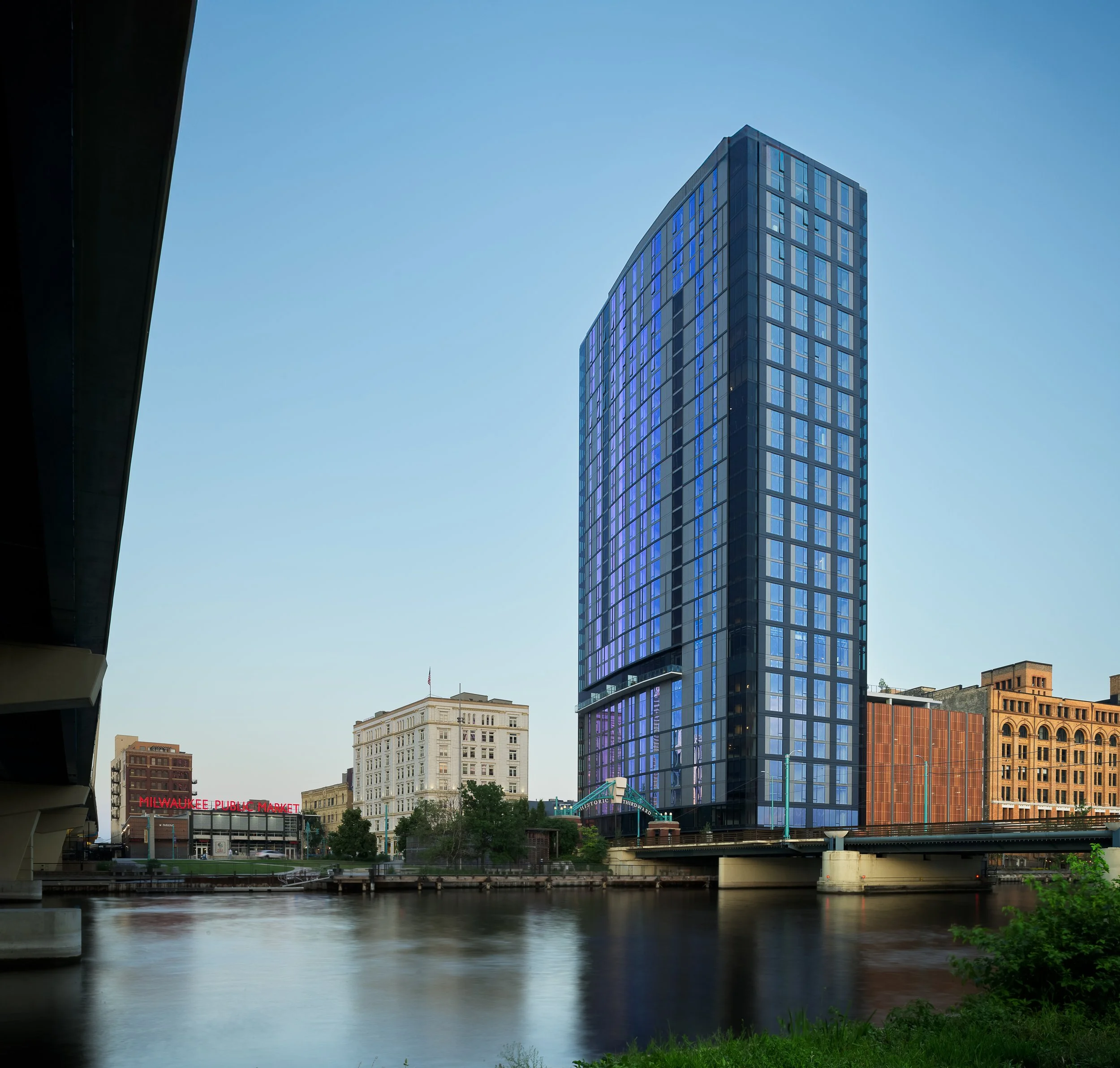 333 Water luxury residential tower rising above the Milwaukee River, viewed from bridge — 31-story high-rise architecture photography, Milwaukee WI