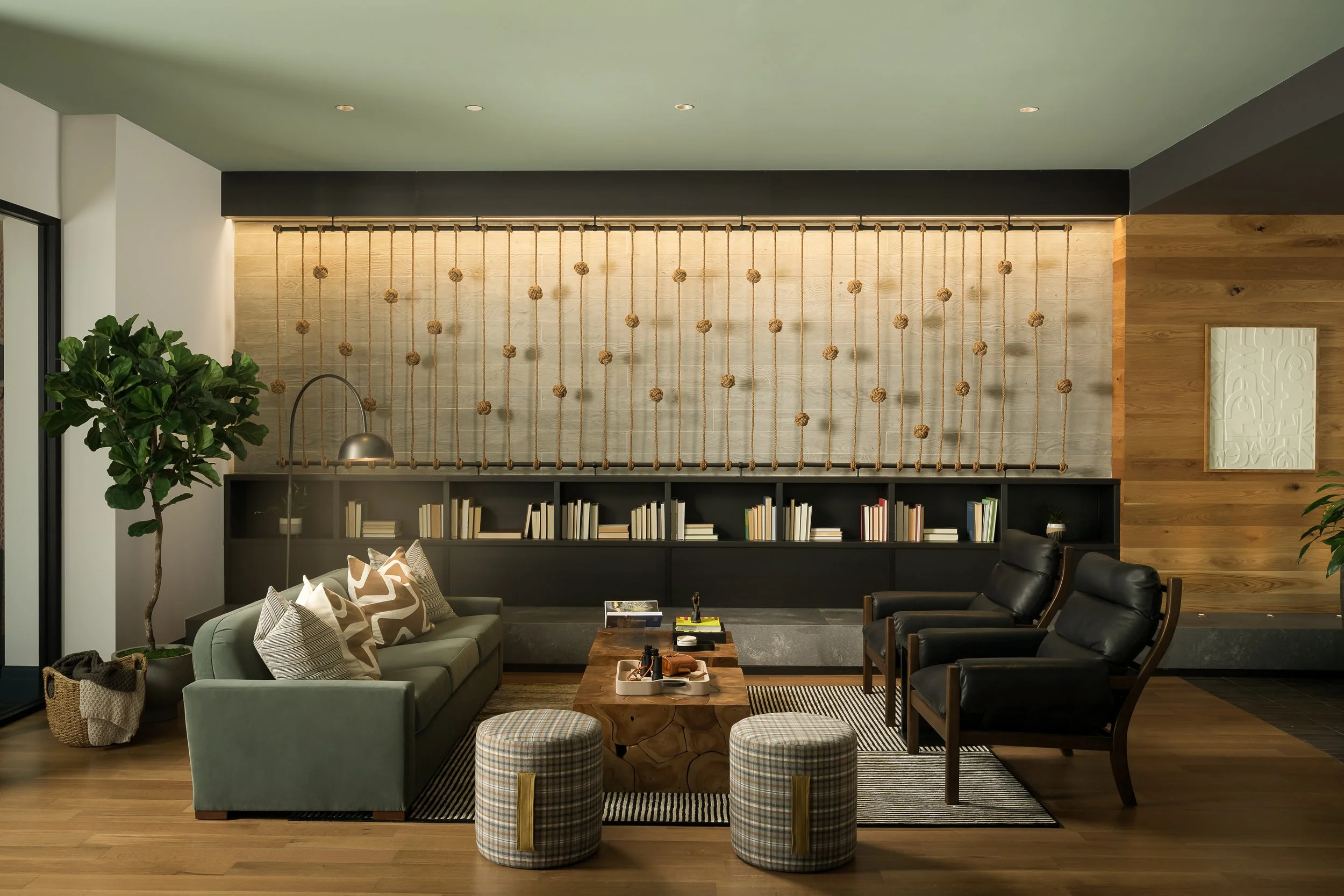 Sophisticated resident lounge with textured accent wall and dark wood shelving — luxury interior design photography, 333 Water Milwaukee WI