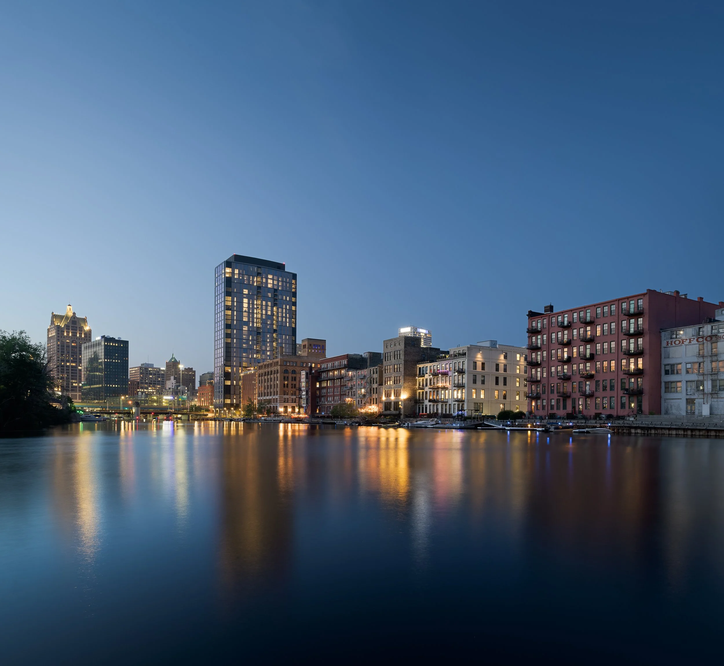 Milwaukee Third Ward waterfront at dusk with city skyline reflected in the river — luxury high-rise architecture photography, Milwaukee WI