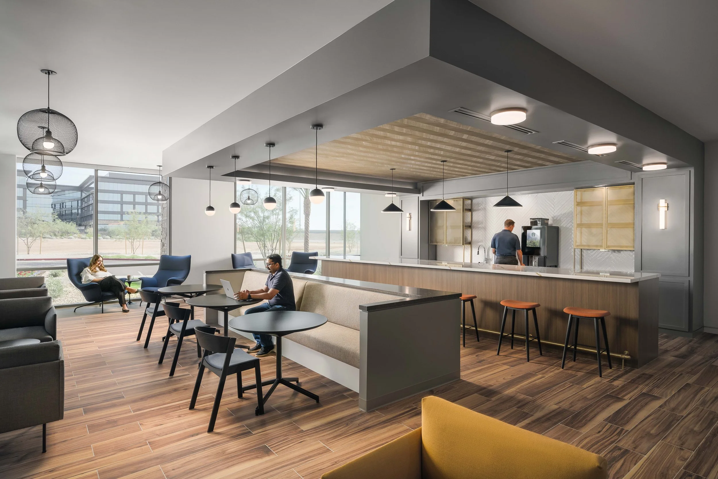 Flexible workplace breakout area with mixed high-top and desk seating, natural light — tech company office interior photography, Choice Hotels Scottsdale AZ