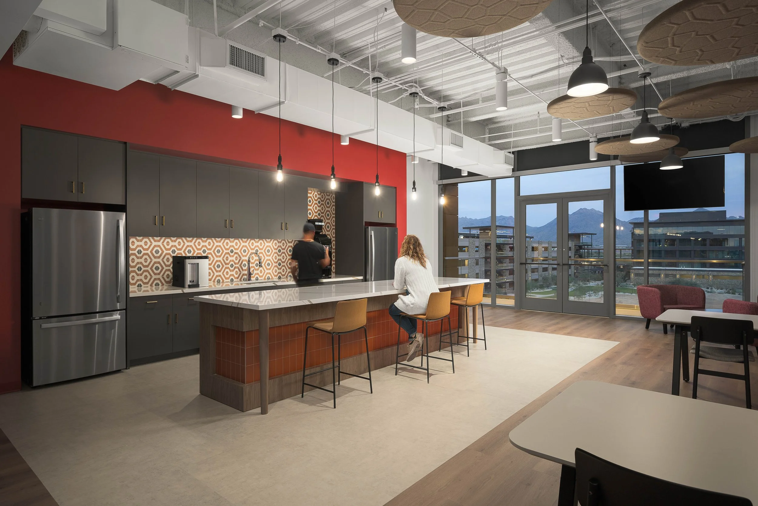 Central workplace hub with orange accent wall, reception desk, and mosaic tile feature — corporate interior photography, Choice Hotels Cavasson Scottsdale AZ