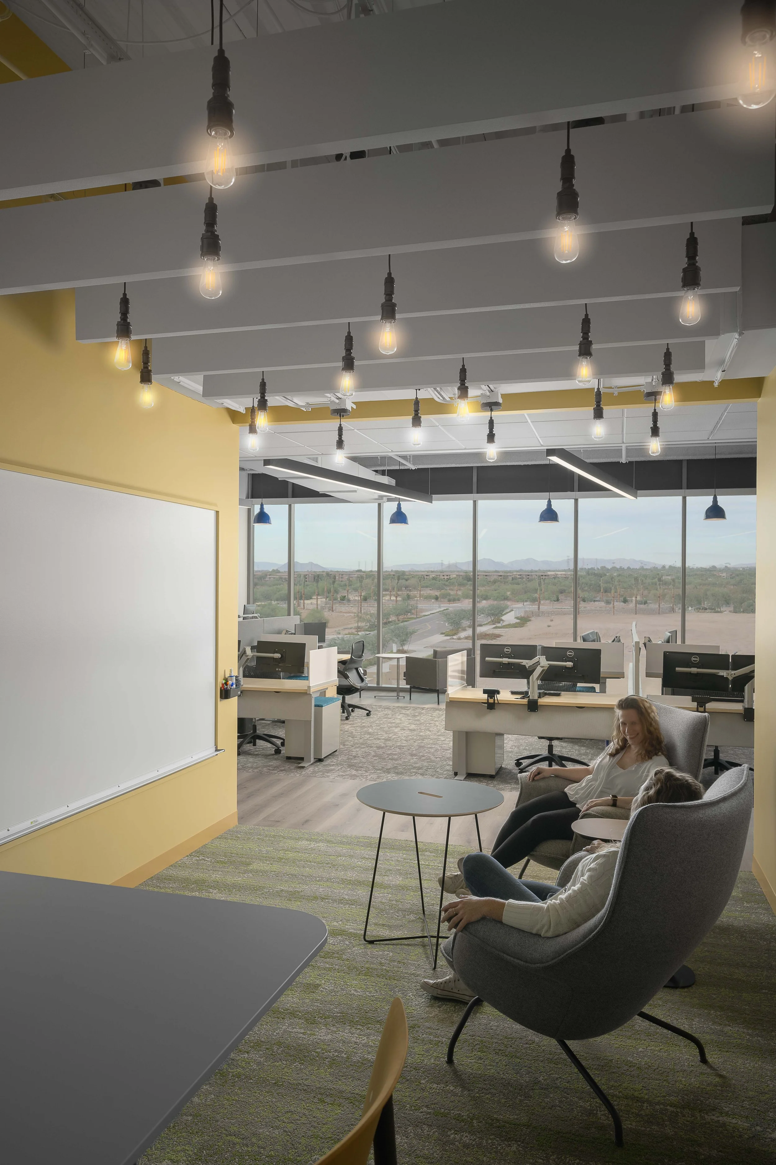 Quiet focus lounge with yellow accent wall, armchairs, and desert mountain views through glass — Choice Hotels Technology HQ, Cavasson Scottsdale AZ