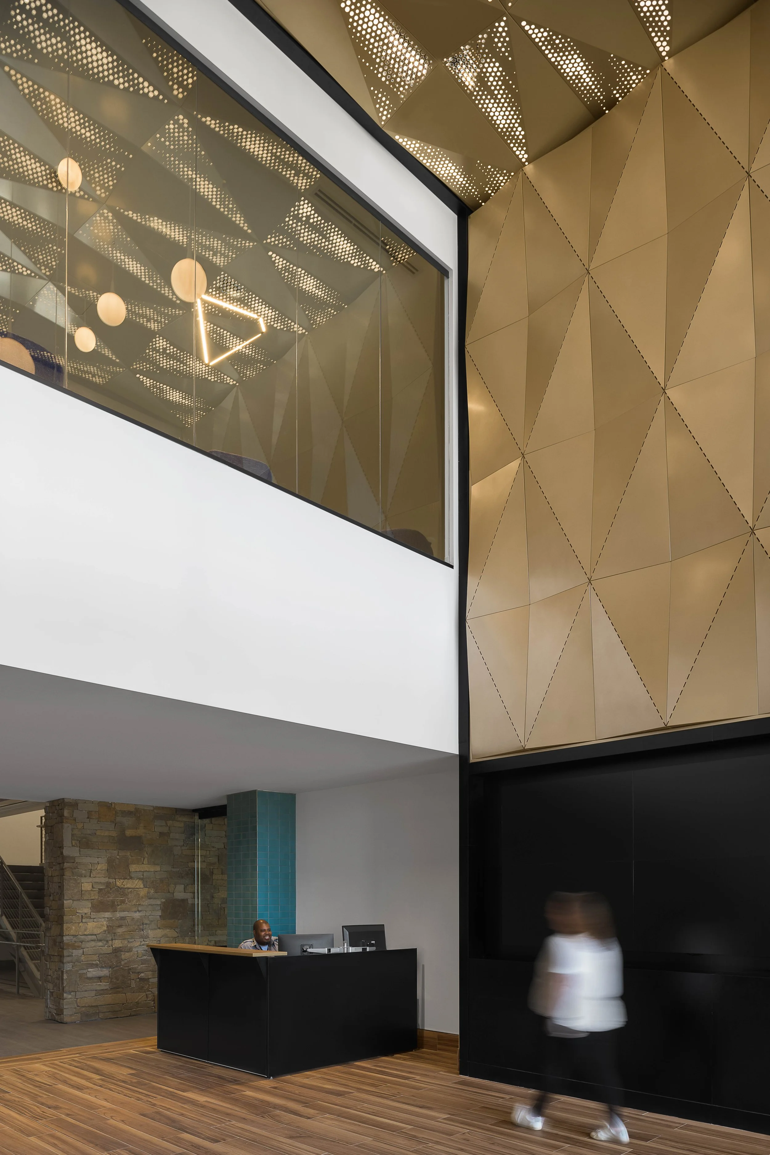 Building facade detail with geometric gold and bronze cladding panel — contemporary commercial architecture photography, Cavasson Scottsdale AZ