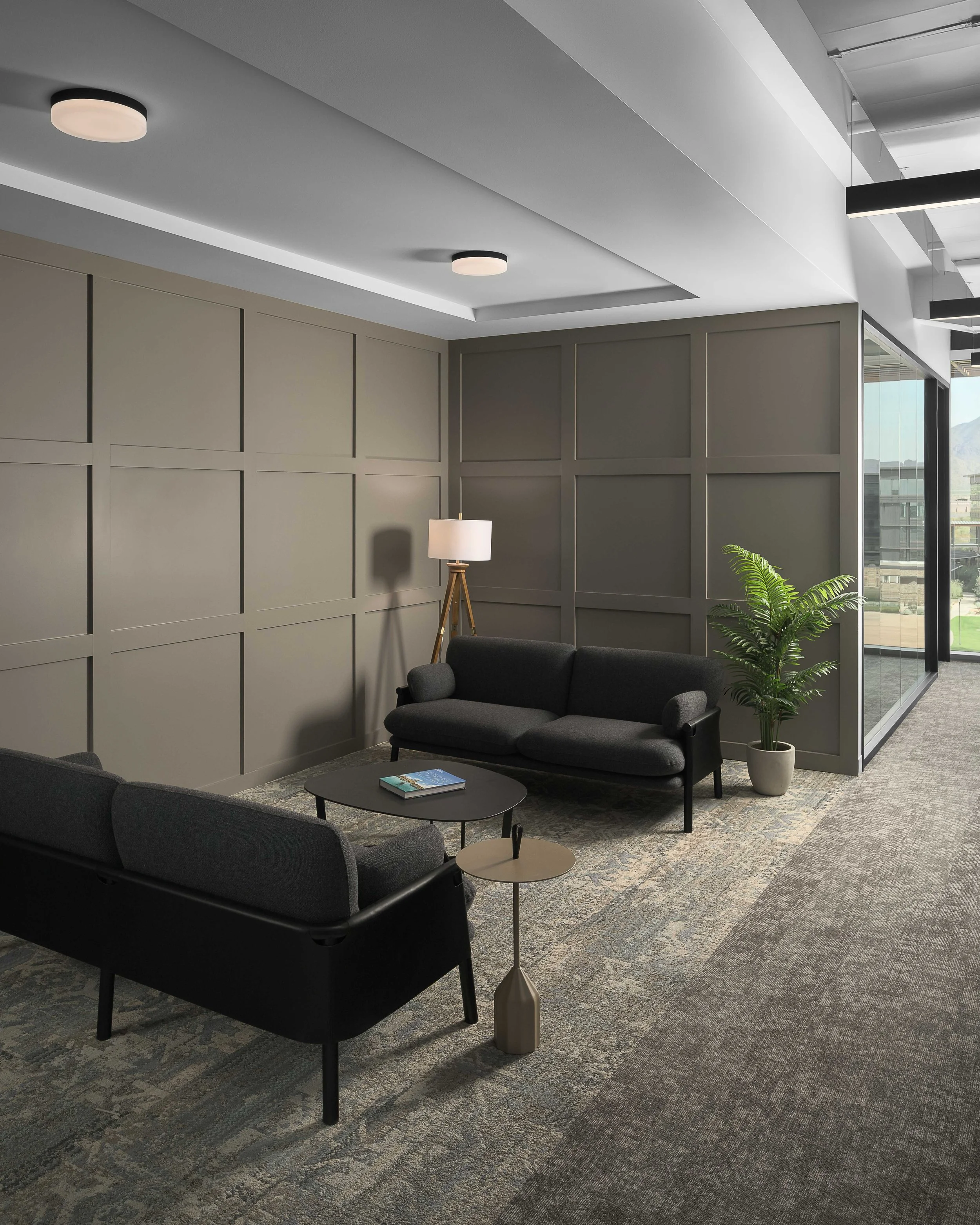Private meeting room with dark acoustic wall panels, modern sofa, and floor lamp — corporate office interior photography, Choice Hotels Scottsdale AZ