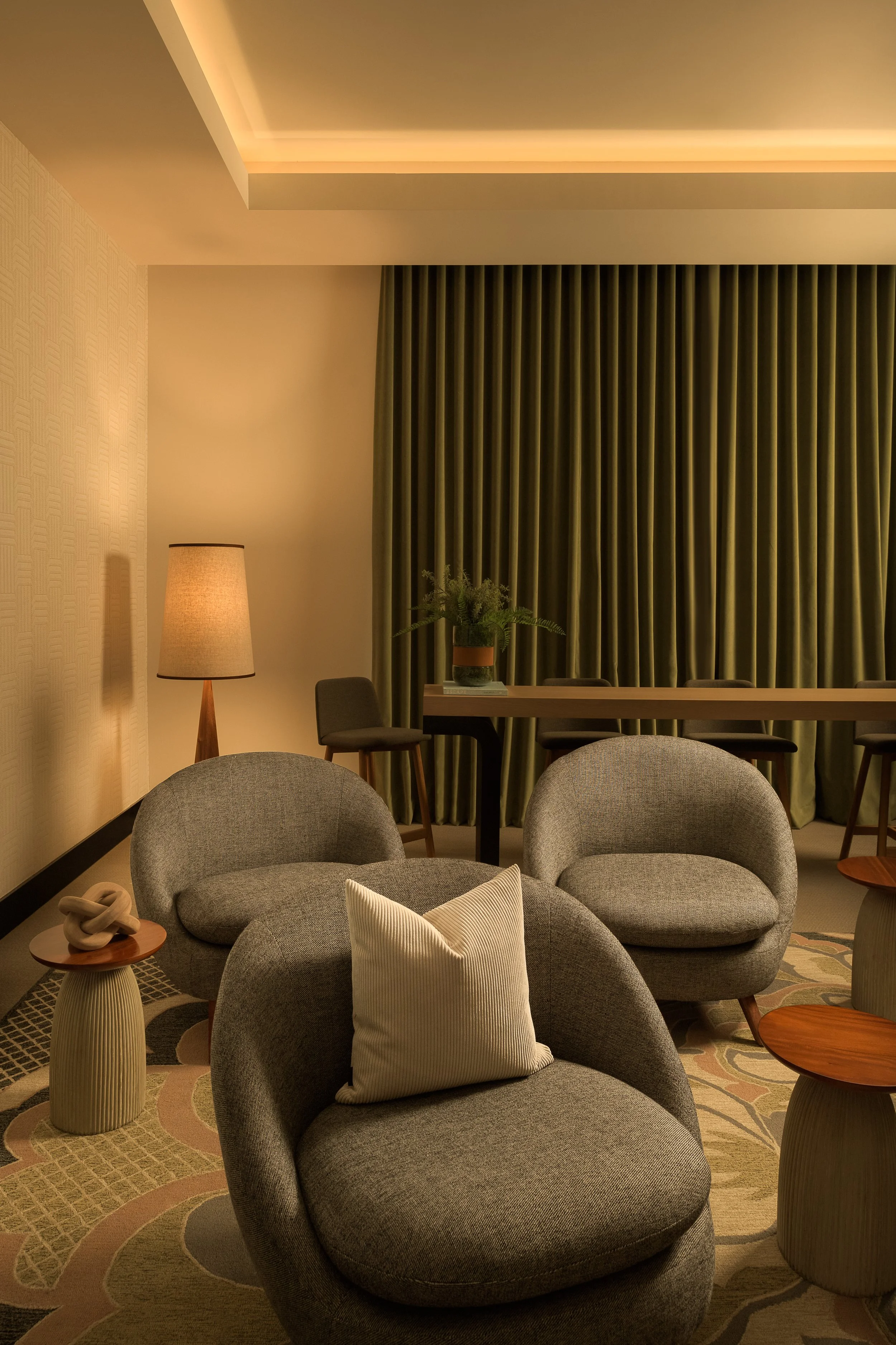 Intimate sitting area with olive wood slat wall, barrel armchairs, and warm ambient lighting — interior design photography, Fort Lauderdale FL