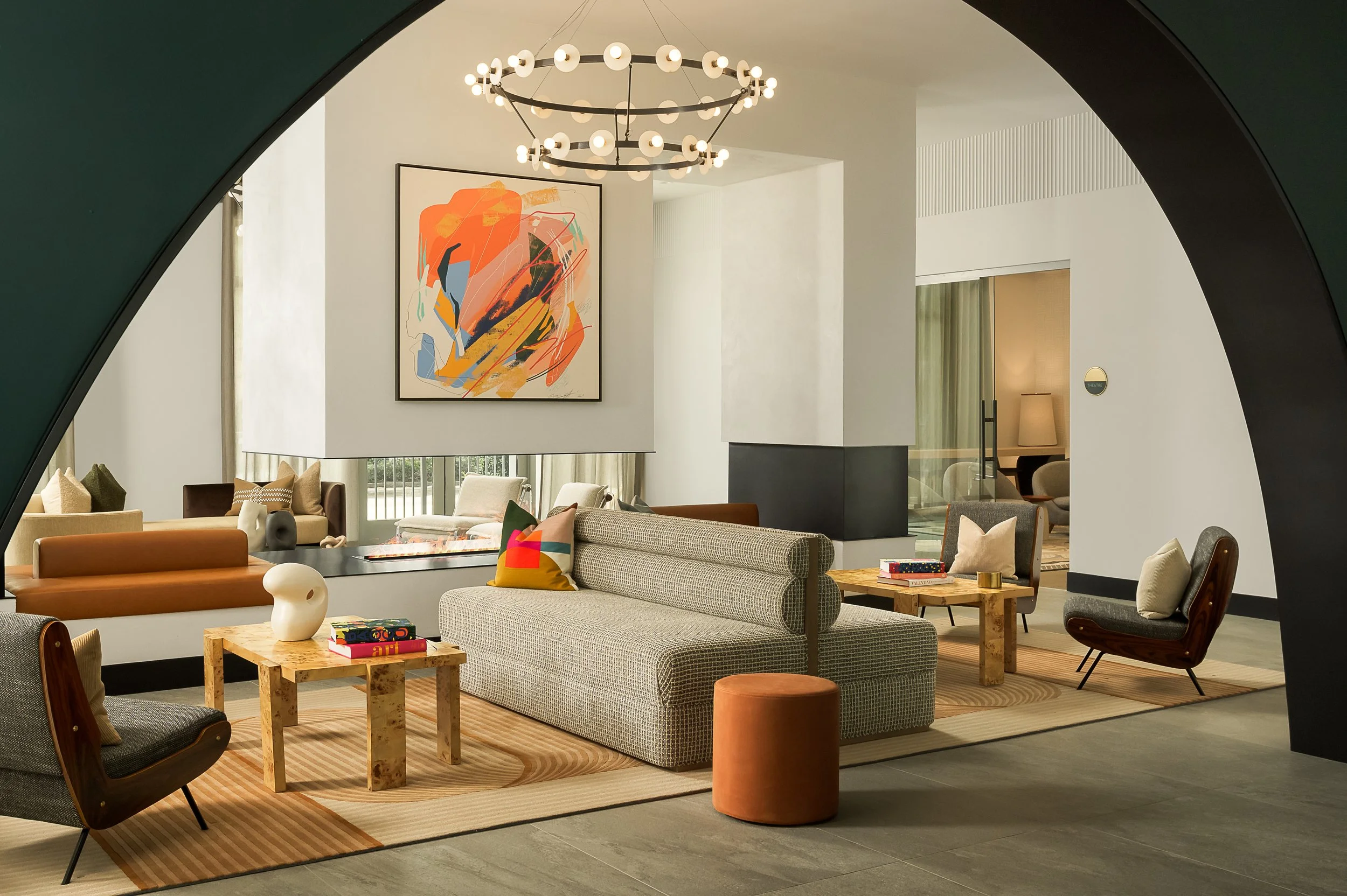 Bright boutique apartment lobby with Sputnik chandelier, abstract wall art, and patterned upholstered seating — Coasterra, Fort Lauderdale FL