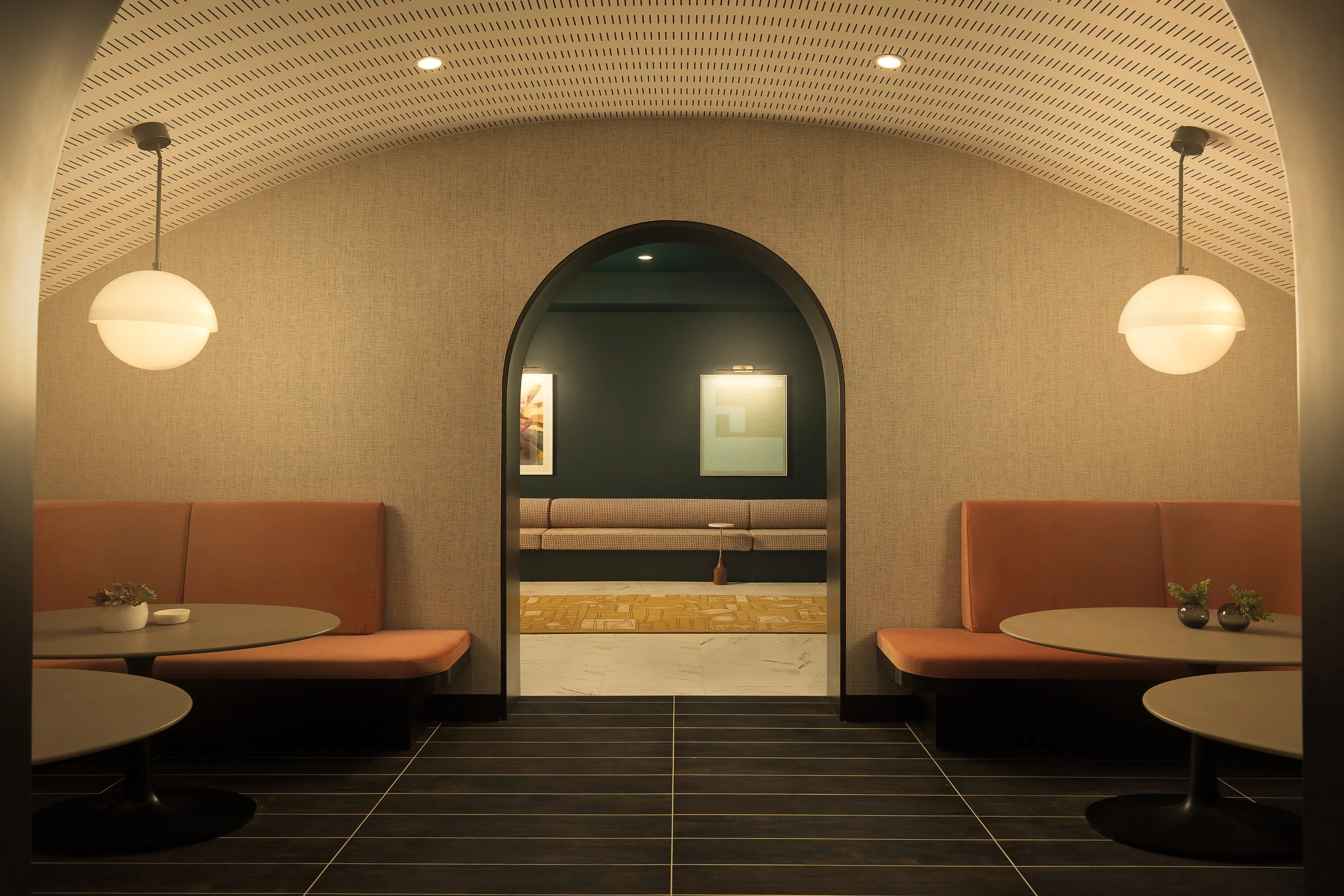 Barrel-vaulted entry corridor with mosaic tile cladding and built-in pink banquette seating — boutique apartment architectural detail, Coasterra Fort Lauderdale FL