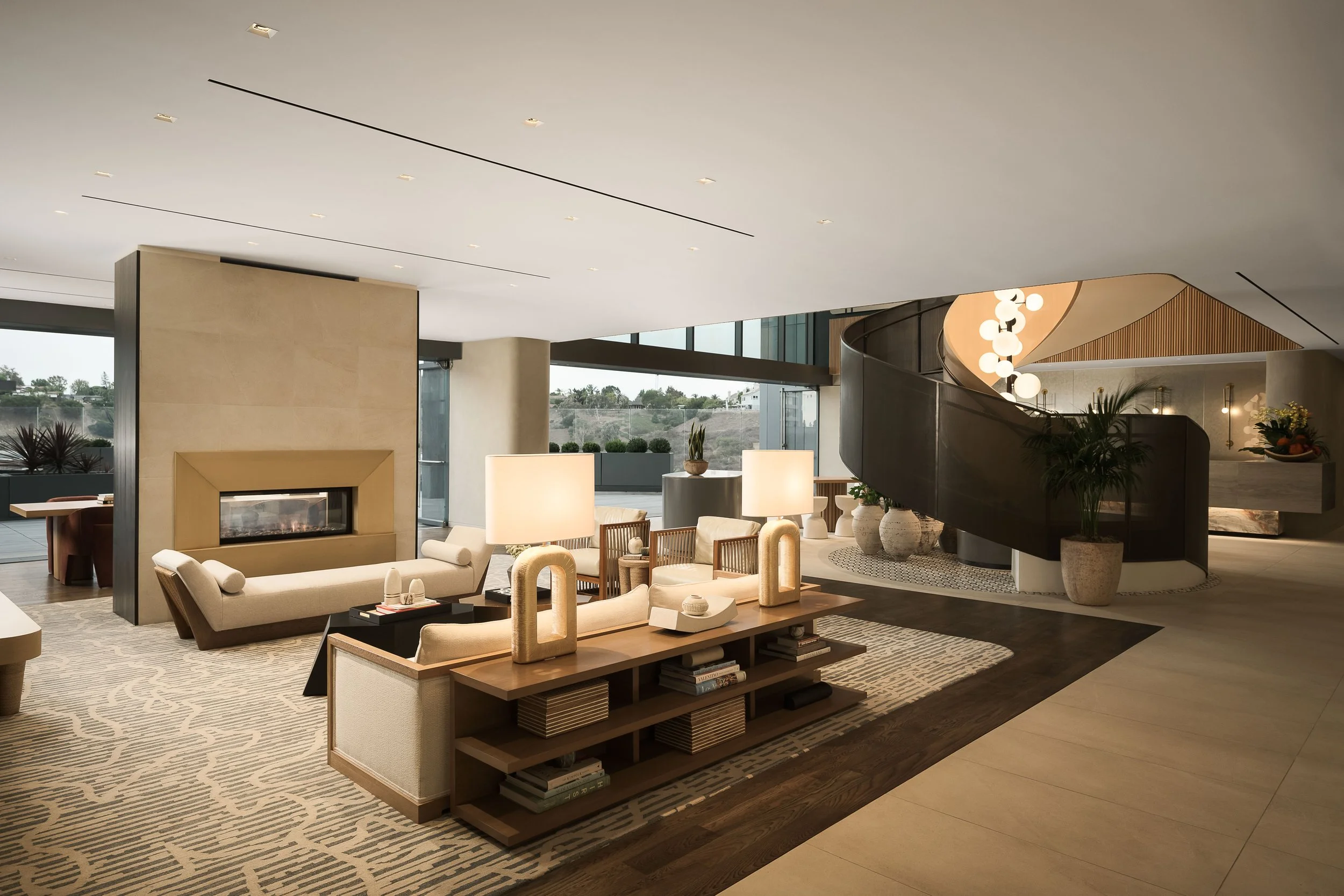 Indoor-outdoor lounge with marble sideboard, brass accessories, and terrace views — luxury commercial interior design photography, Los Angeles CA