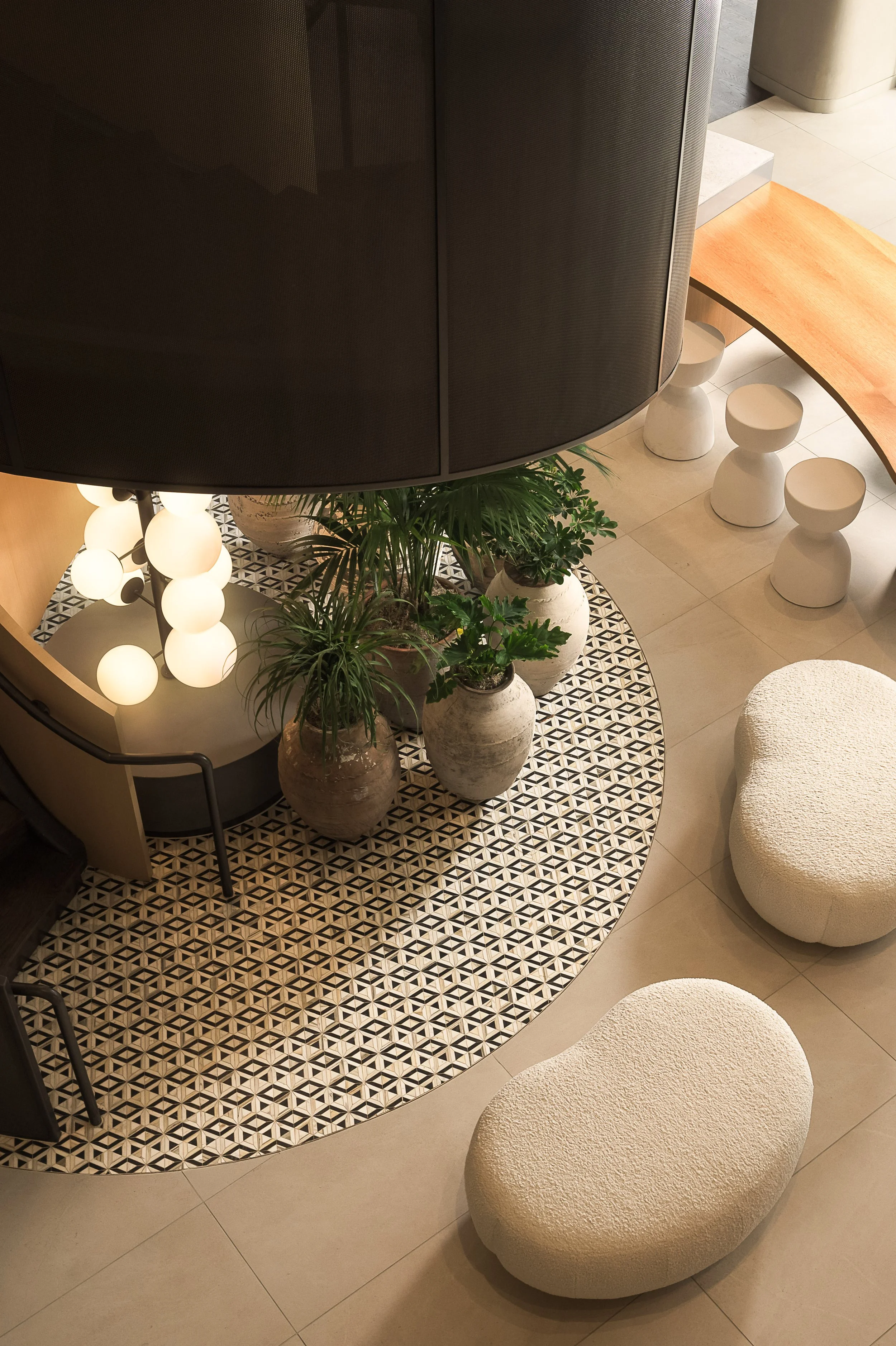 Detail of sculptural globe pendant light cluster above organic white stools and patterned tile floor — interior design photography, Los Angeles CA