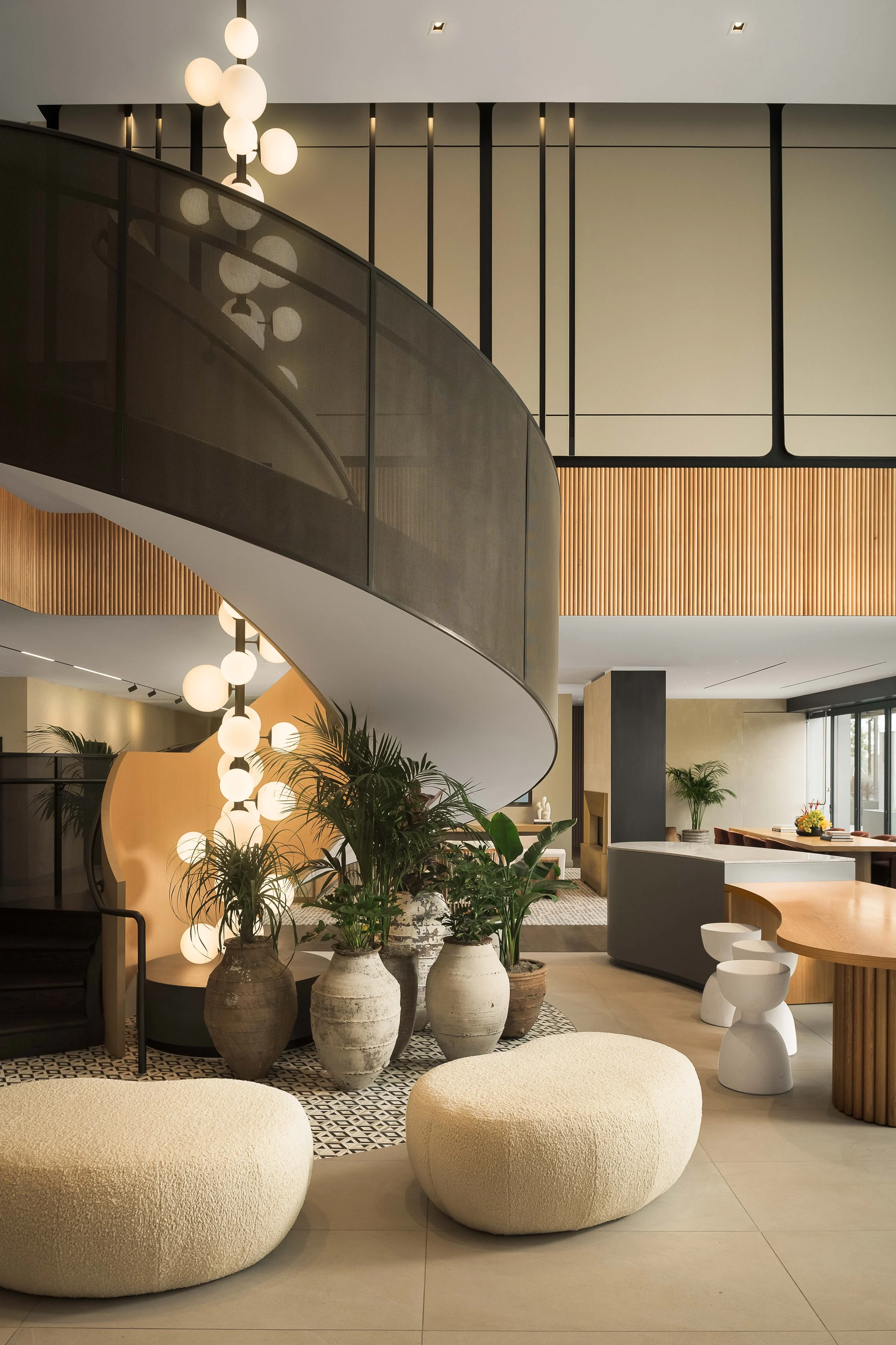 Upscale residential interior with curved staircase and warm lighting — luxury interior photography