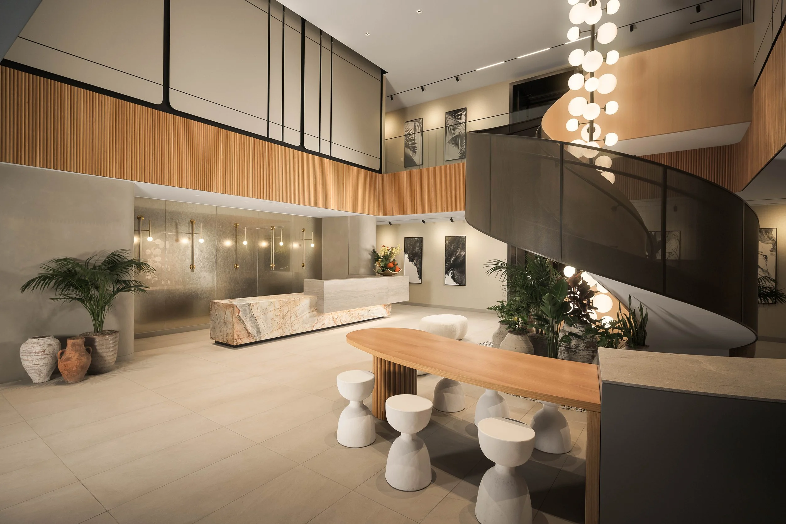 Double-height lobby with grid pendant lighting, warm wood tones, and open-plan design — luxury mixed-use interior photography, Entrada Los Angeles CA