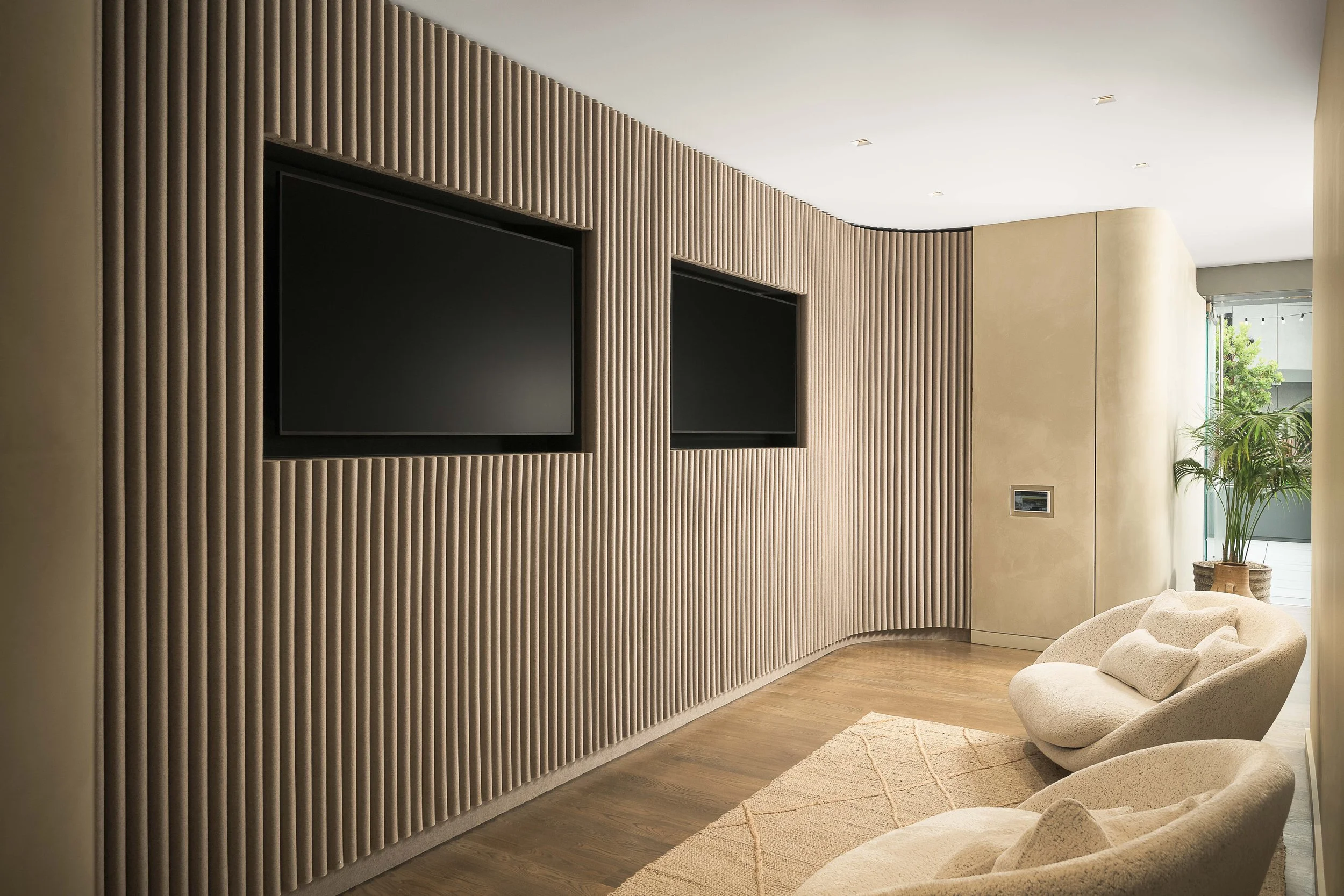Media lounge with vertical wood slat wall, integrated TV, and minimalist upholstered seating — luxury interior design photography, Entrada Los Angeles CA