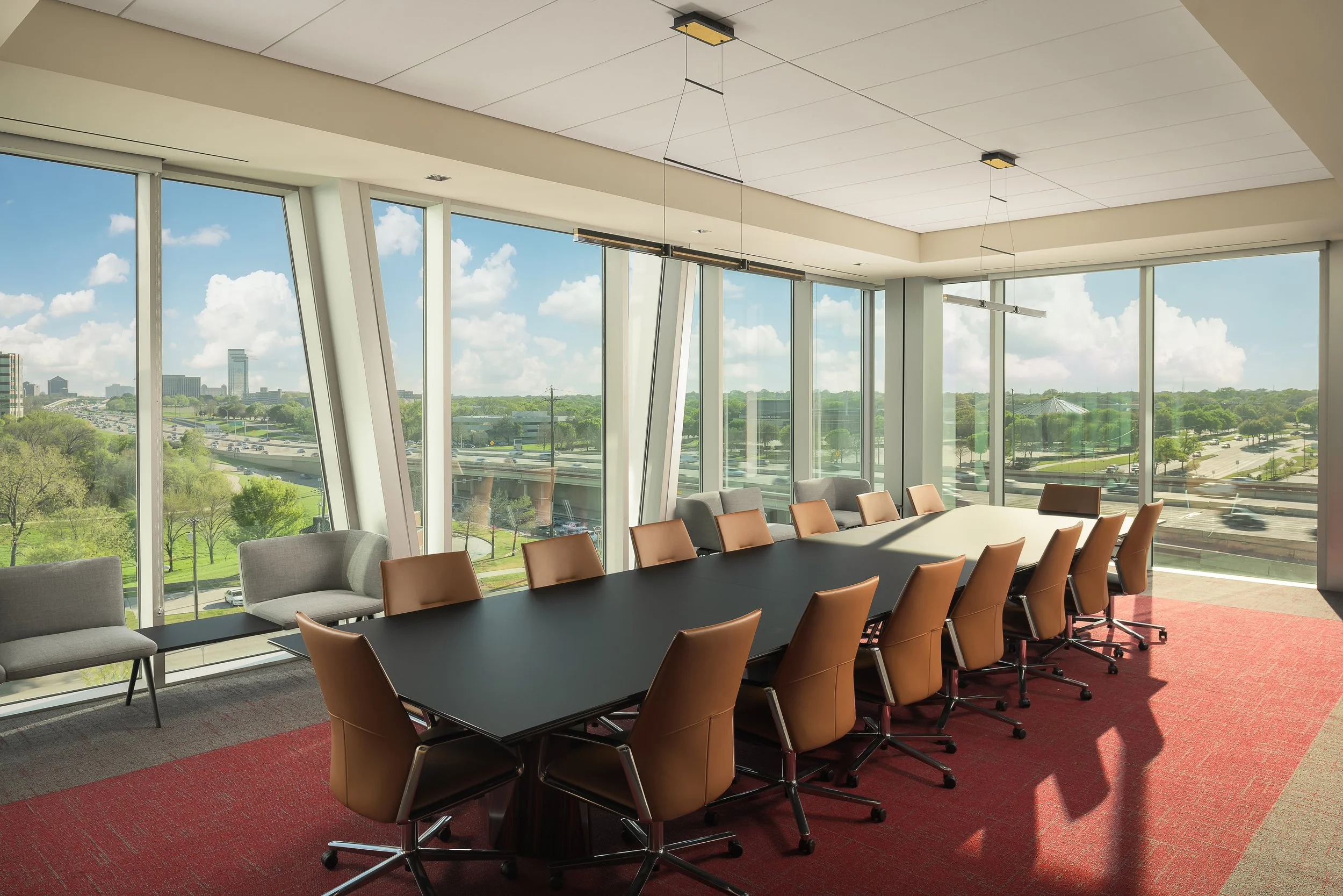 Executive boardroom with long dark conference table, leather chairs, and panoramic floor-to-ceiling views — corporate interior photography, McCarthy Building Companies Richardson TX