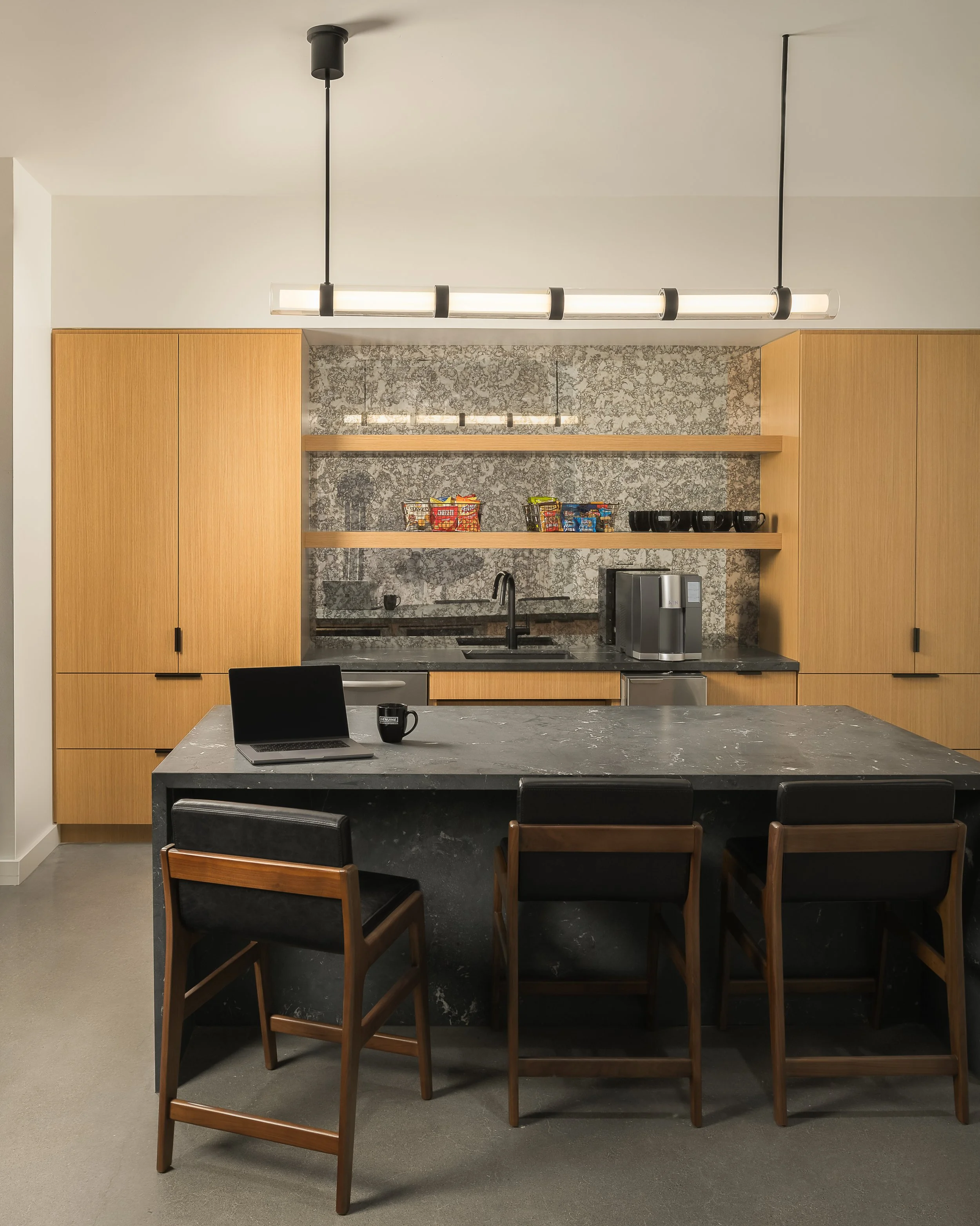 Individual workstation with backlit mosaic tile feature, warm wood cabinetry, and integrated monitor — corporate office interior photography, McCarthy TX