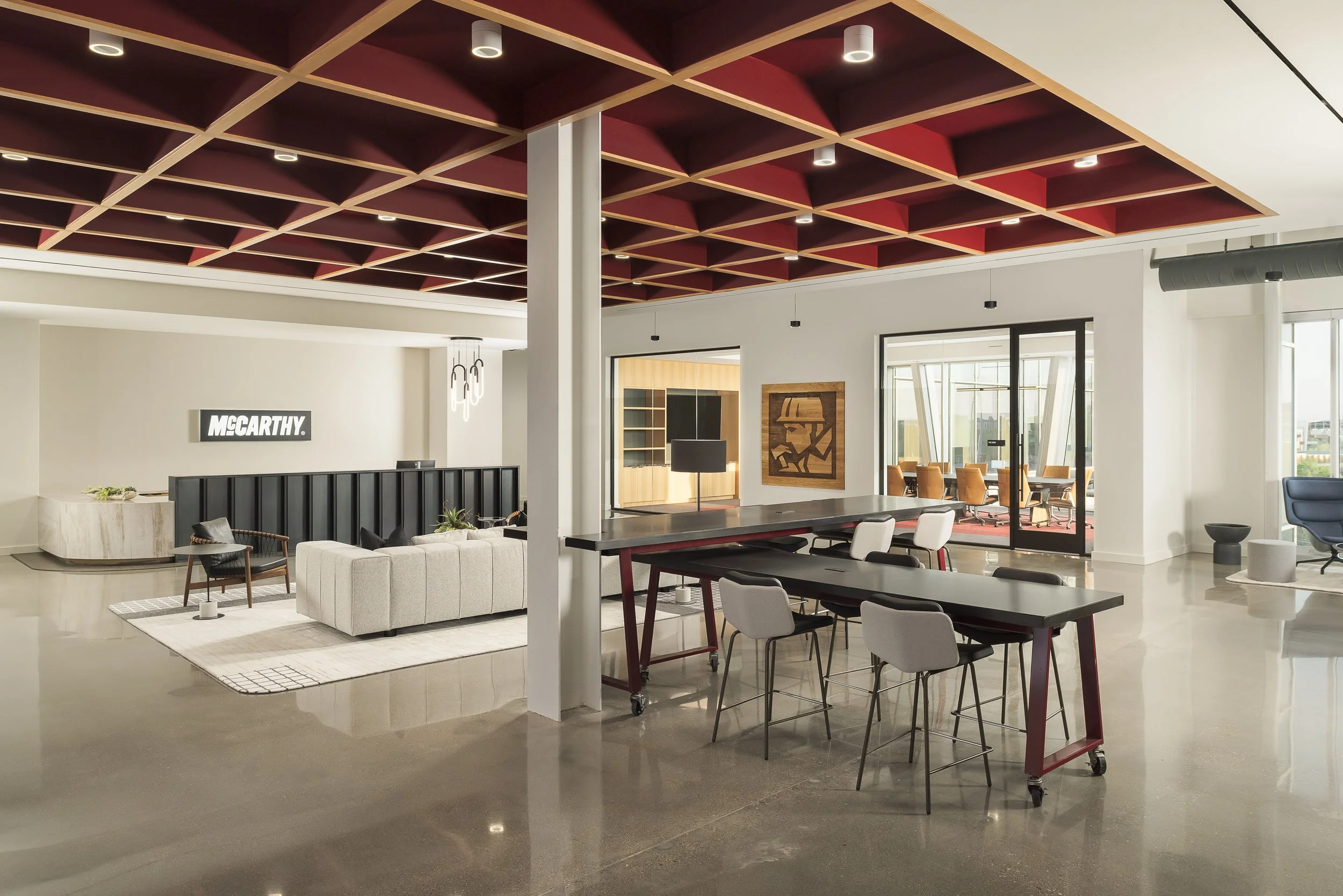 Open-plan office with dramatic dark red coffered ceiling, polished concrete floors, and industrial design — commercial interior photography, Richardson TX
