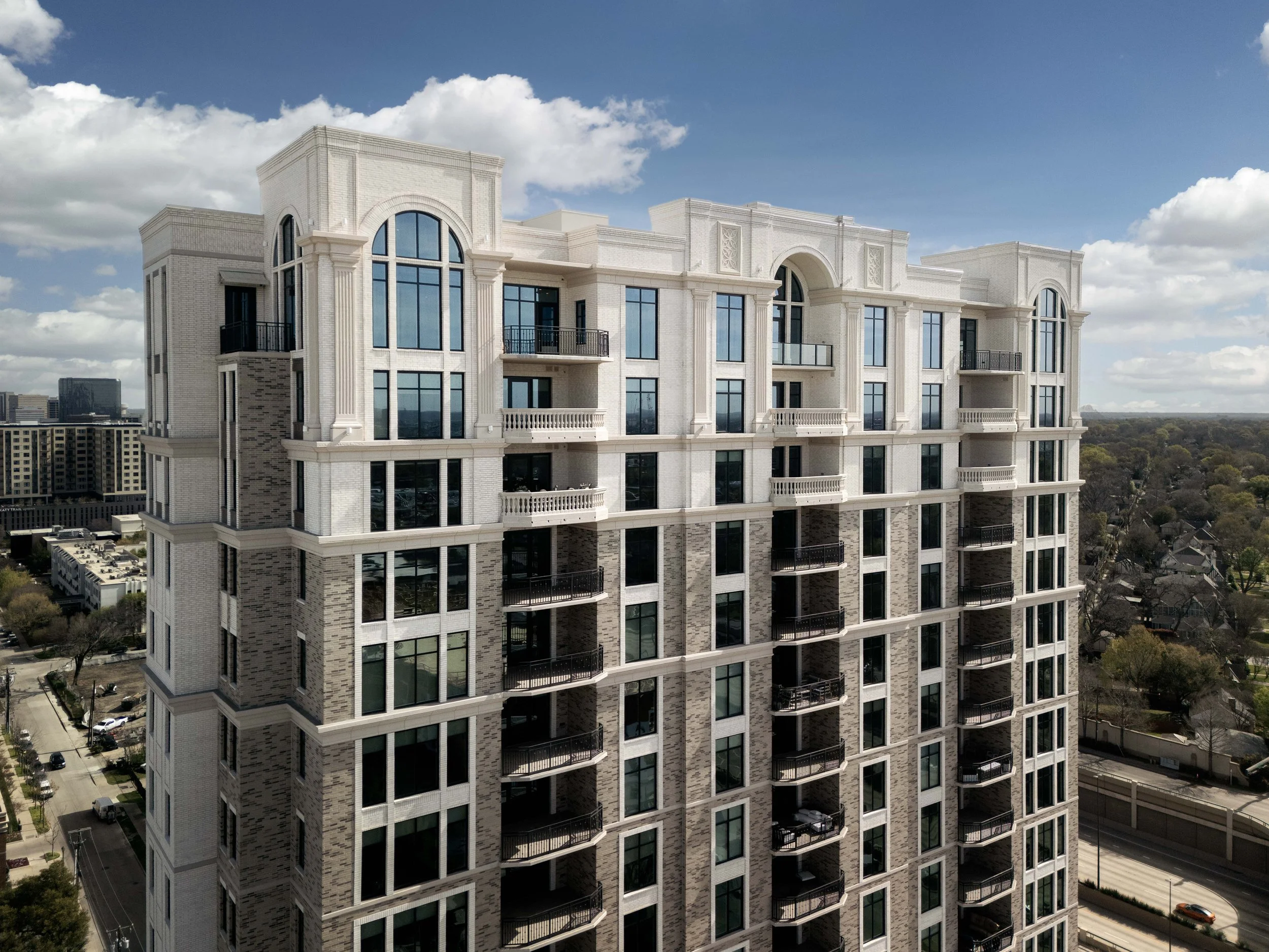 Aerial close-up of residential tower upper floors and balconies — architectural drone photography, The Galatyn Dallas TX