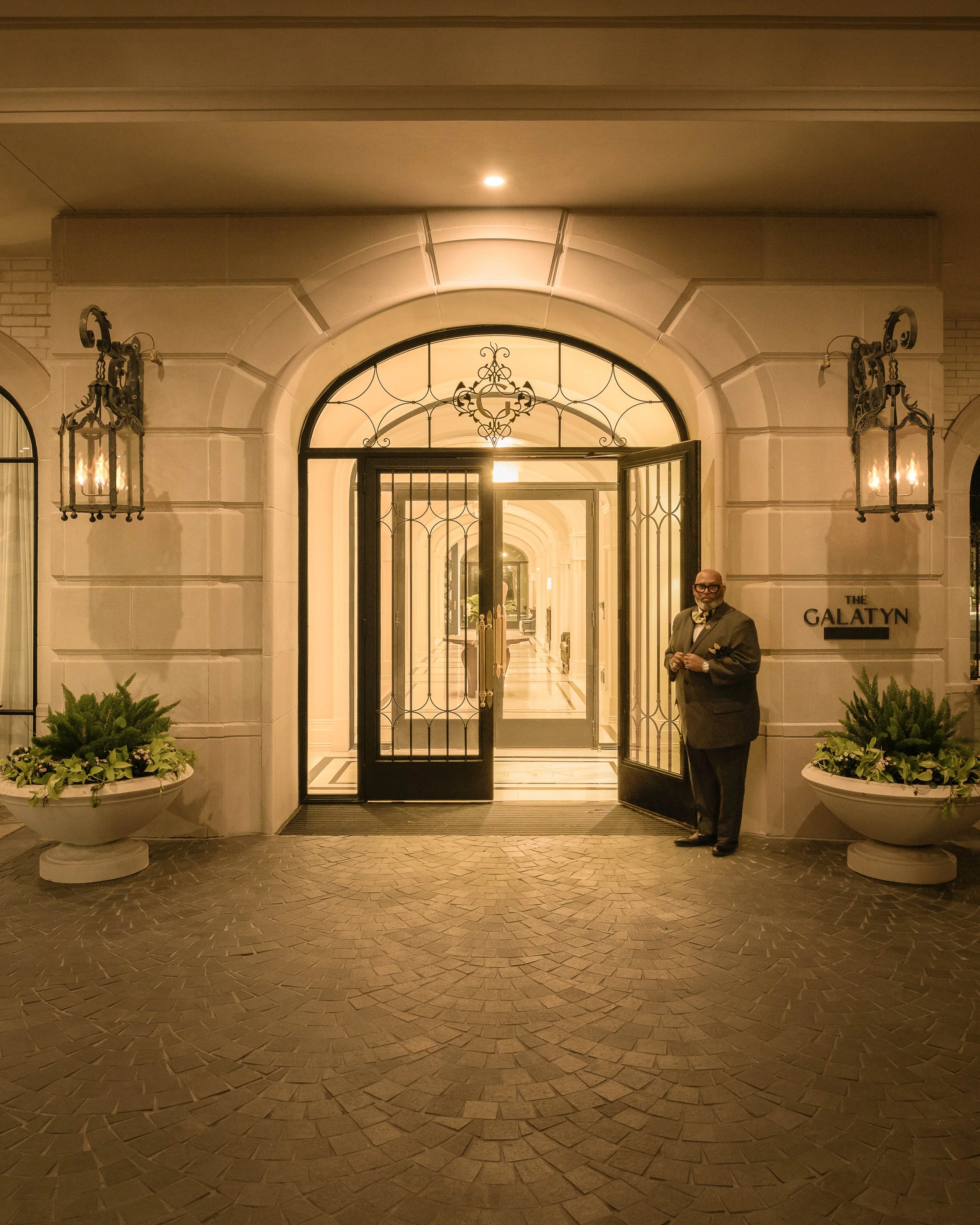 Grand residential entry with iron-arched doorway and stone columns, luxury architectural detail — The Galatyn, Dallas TX
