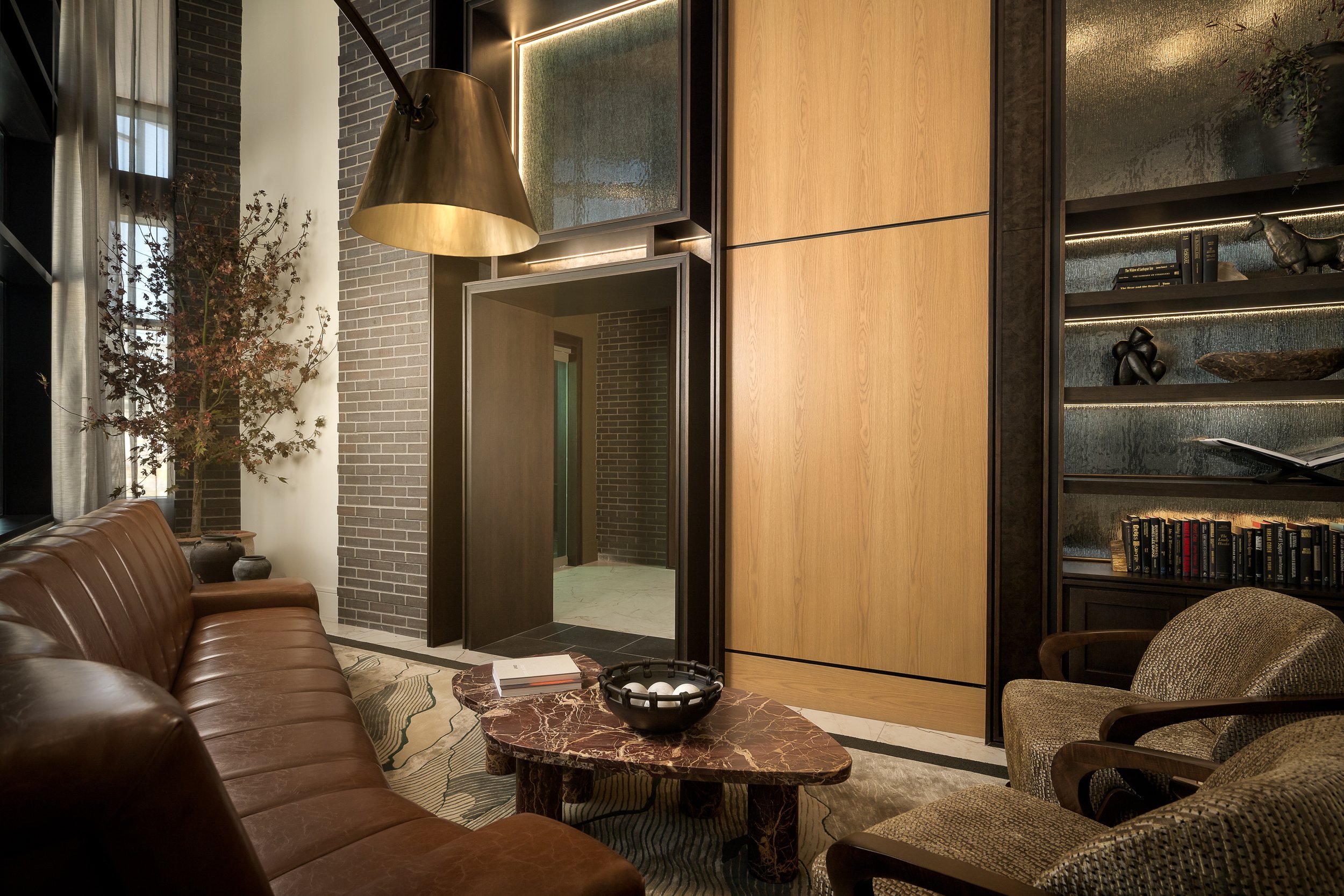 Warm-toned residential entry foyer with bronze pendant lamp and natural wood finishes — luxury interior photography, Dallas TX