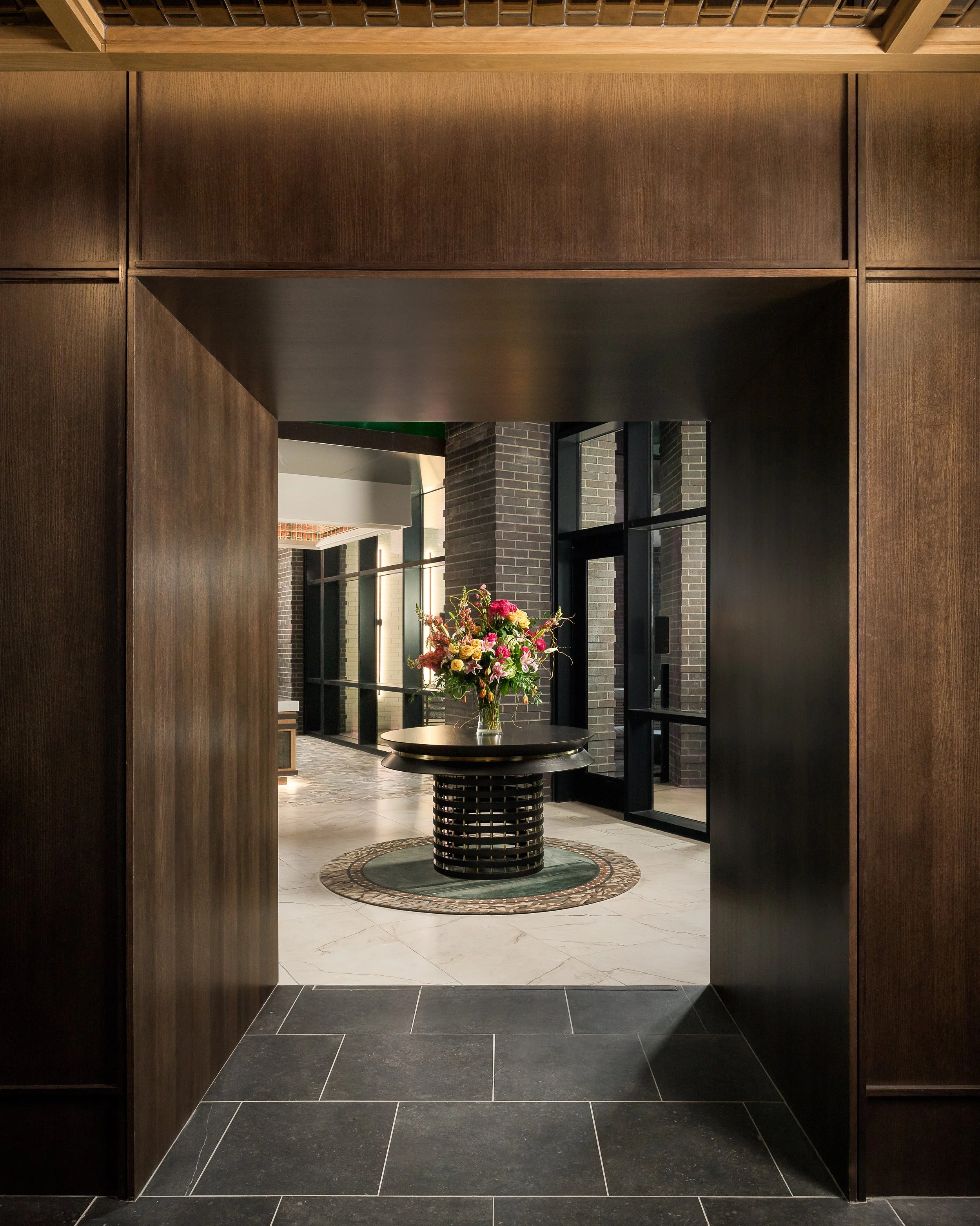 Dramatic hotel lobby intSophisticated hotel bar with bottle display wall and dramatic pendant lighting — hospitality interior photographyerior with high ceilings and moody lighting — hospitality interior photography