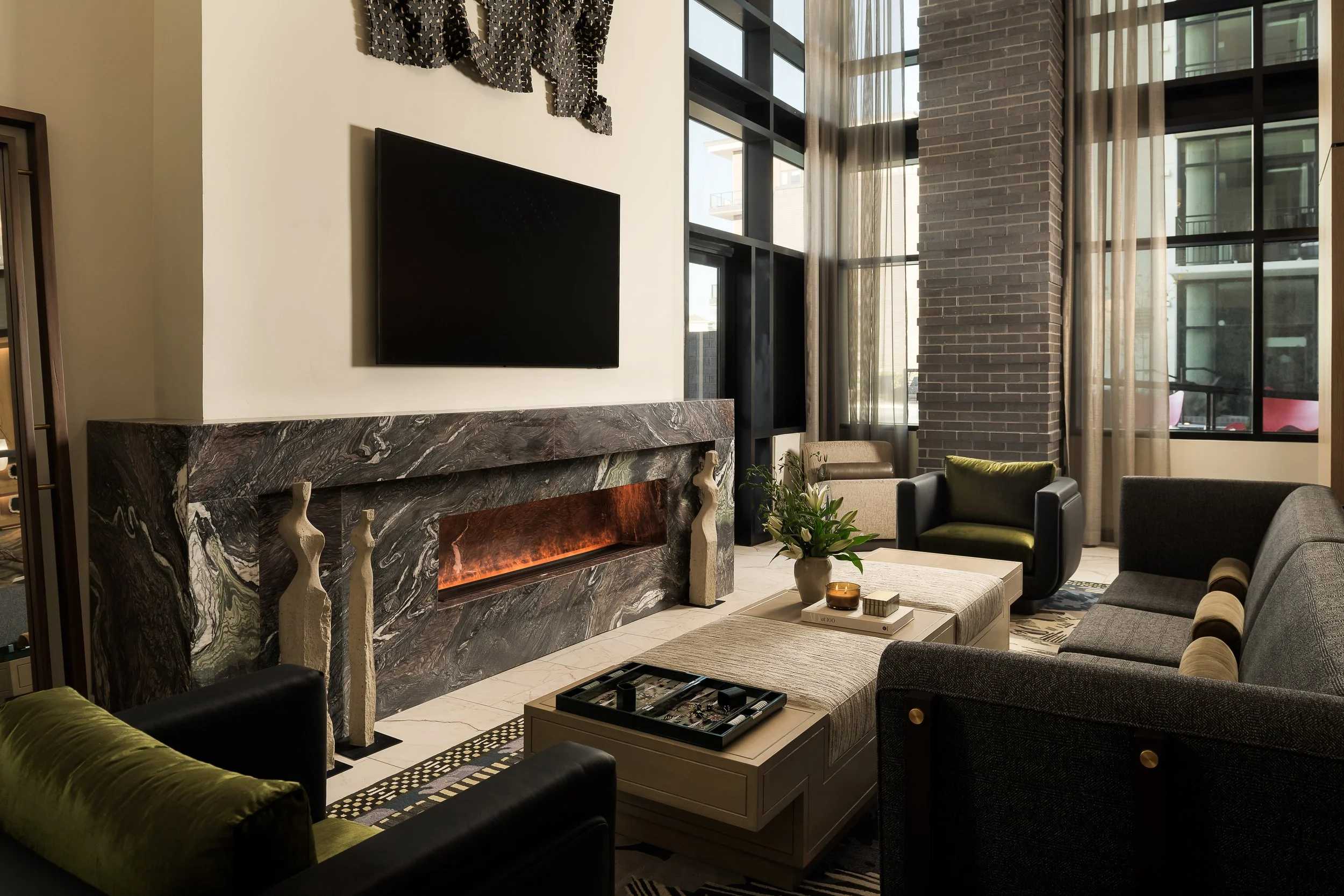 Modern living area with ornate stone fireplace surround, flat screen TV, and layered textures — luxury interior design, Dallas TX