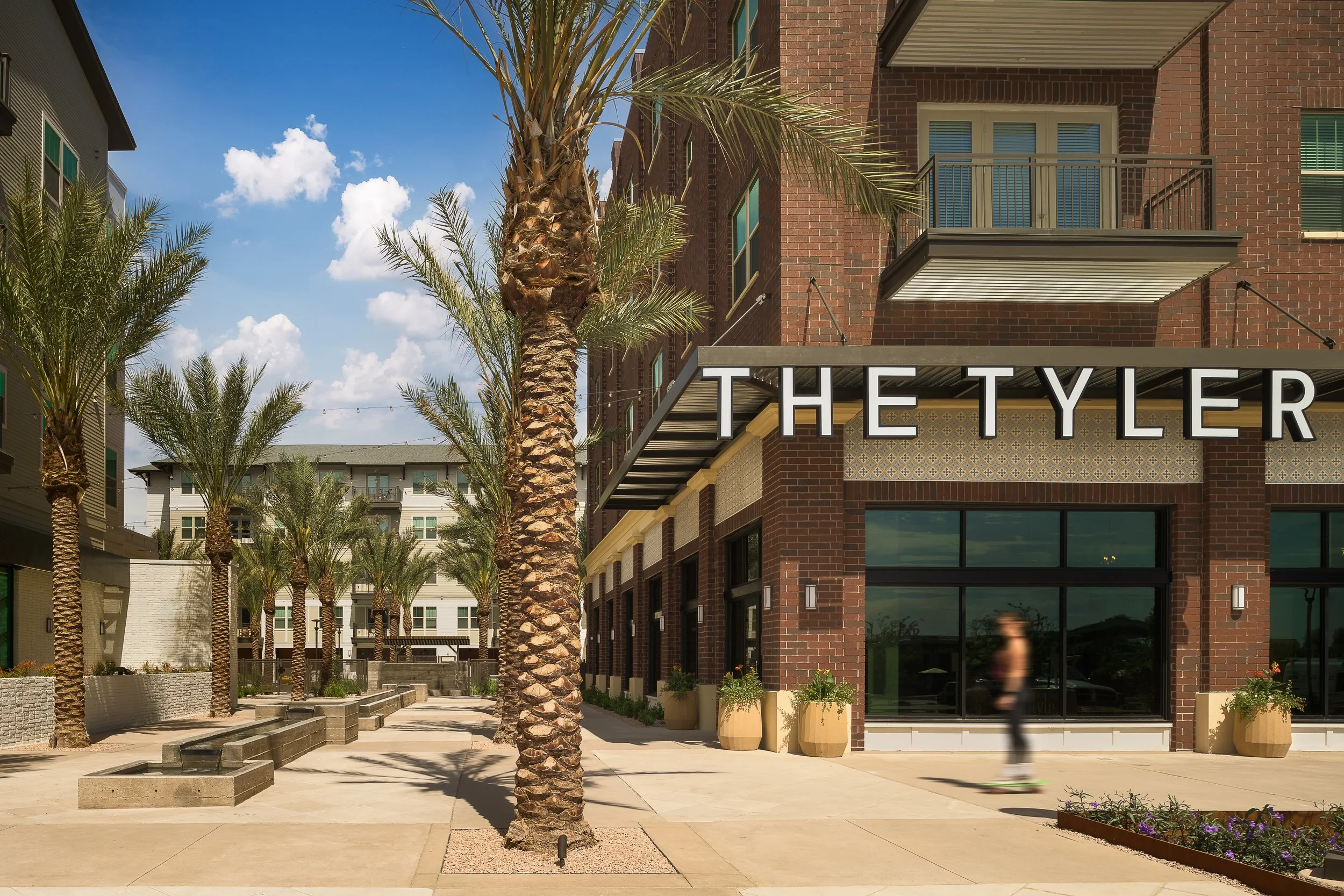 Commercial building enDesert commercial property exterior with palm trees and illuminated entrance at dusk — commercial architecture photographytrance with mature palm trees and evening illumination — commercial architecture photography