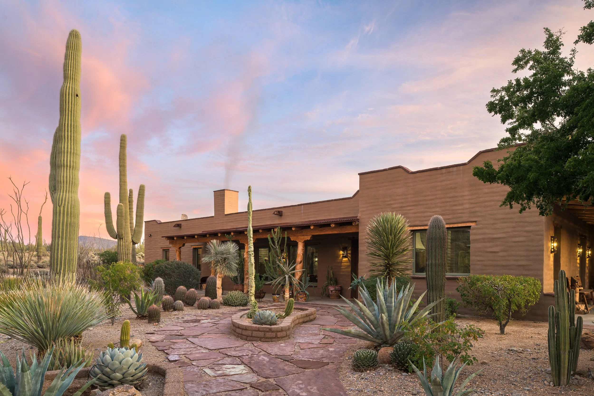 Desert Southwest home exterior at sunset with saguaro cactus and stone courtyard — residential architecture photography Arizona