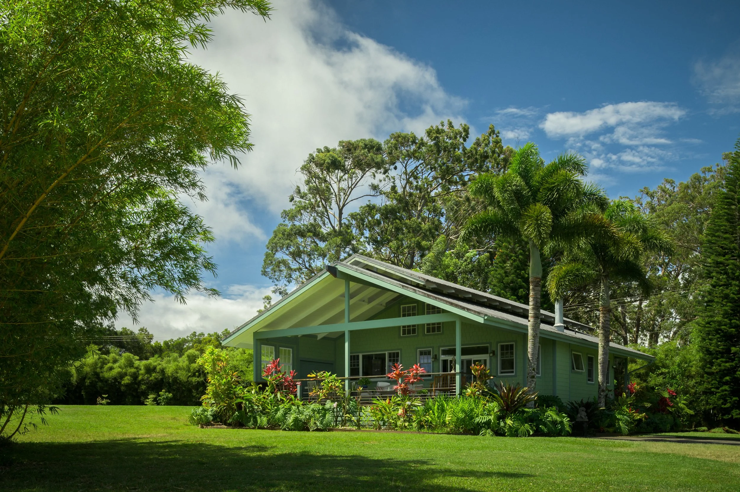 Tropical ranch house exterior with lush greenery and metal roof — residential architecture photography Maui Hawaii