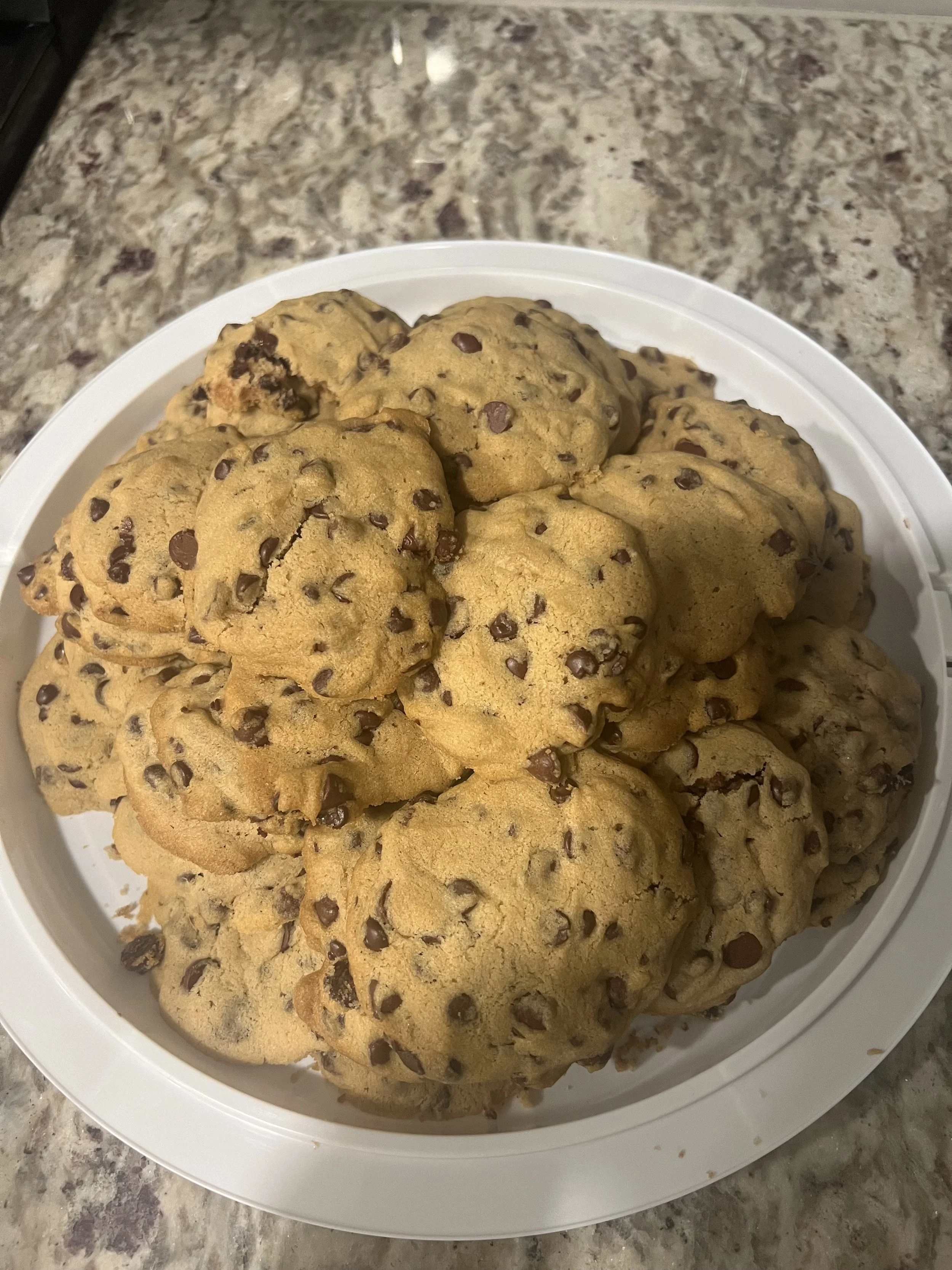 Plate of chocolate chip cookies on a granite countertop.