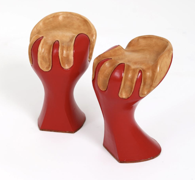Two decorative vases resembling paint cans with red bases and dripping brown paint on top, set against a white background.