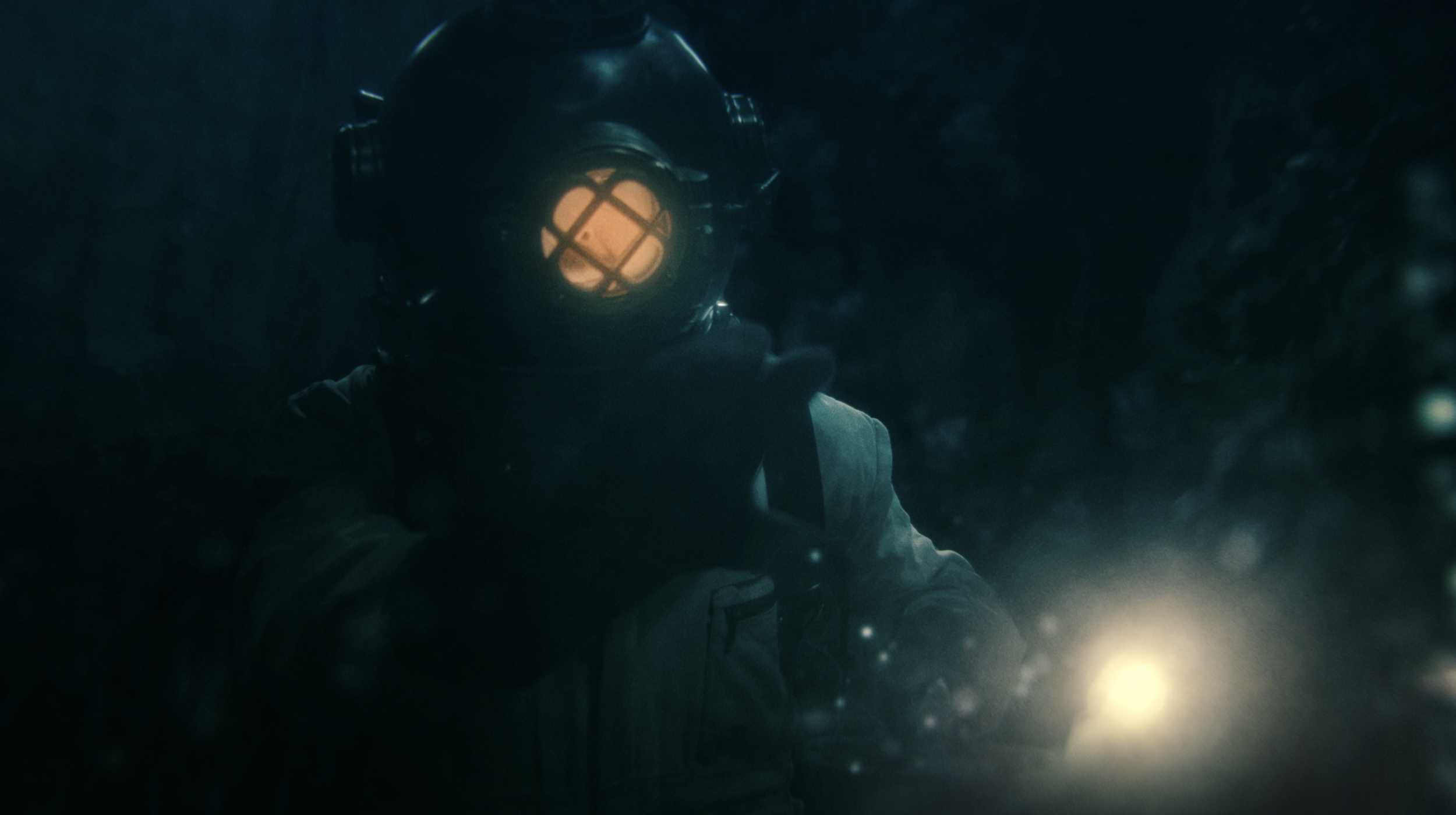 A person wearing a diver helmet with an orange glow inside, underwater in a dark, murky environment.