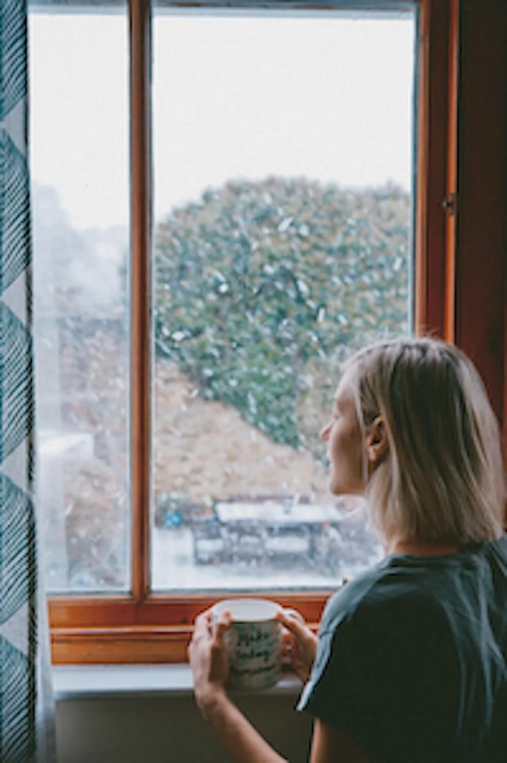 Woman looking out a window at snow looking for hope with Unscripted Medicine Alaska