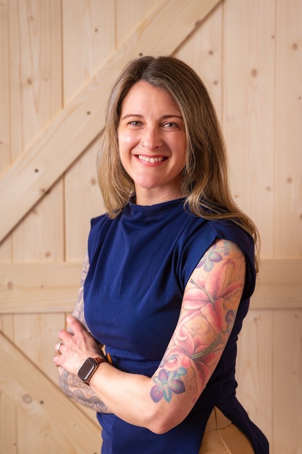 Psychiatry PA in Alaska smiling with tattooed arms crossed offering holistic whole body mental wellbeing for sustainable health