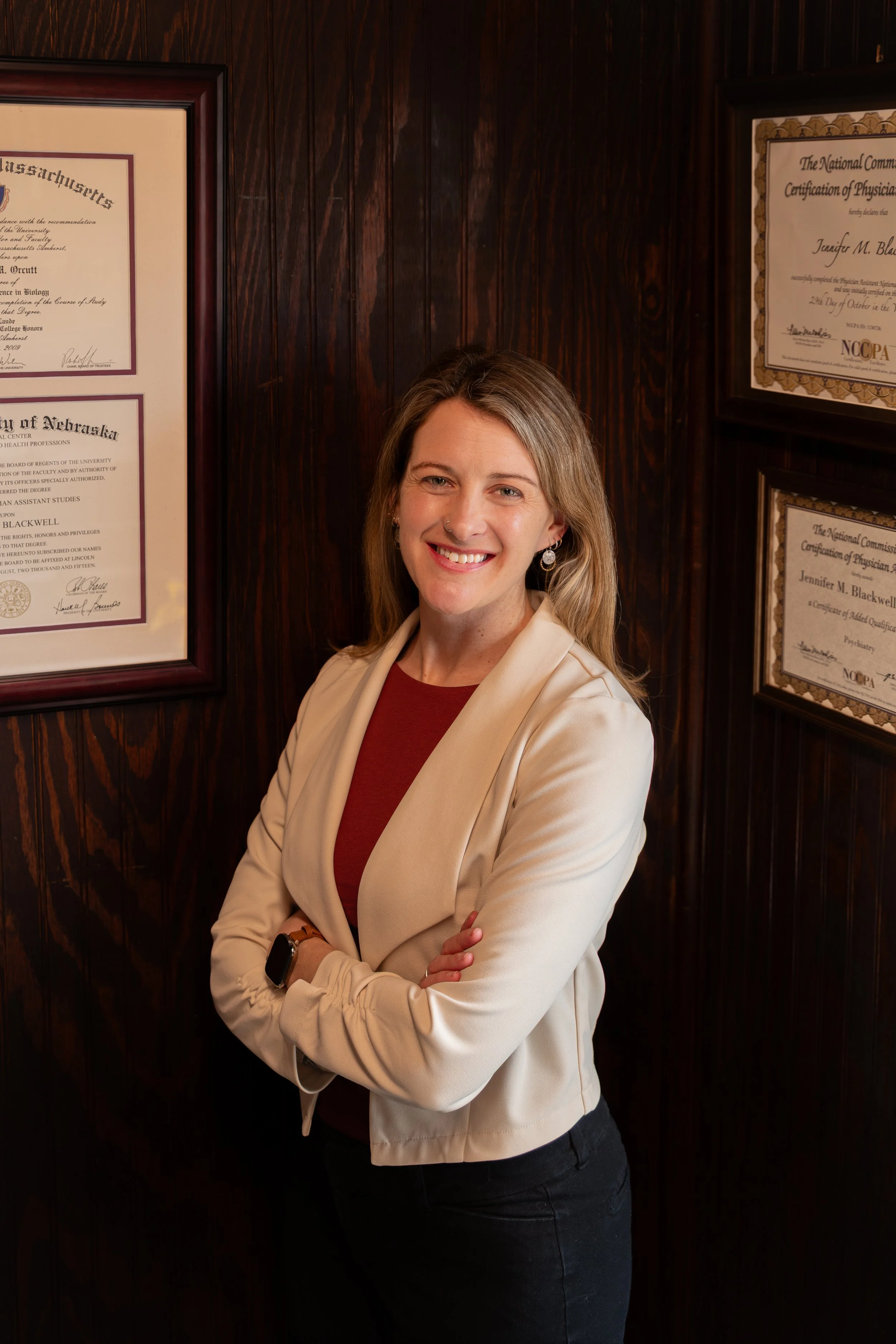 Jenn Blackwell, Board-Certified Psychiatric PA and Functional Medicine Provider in Alaska, smiling in front of her professional certifications