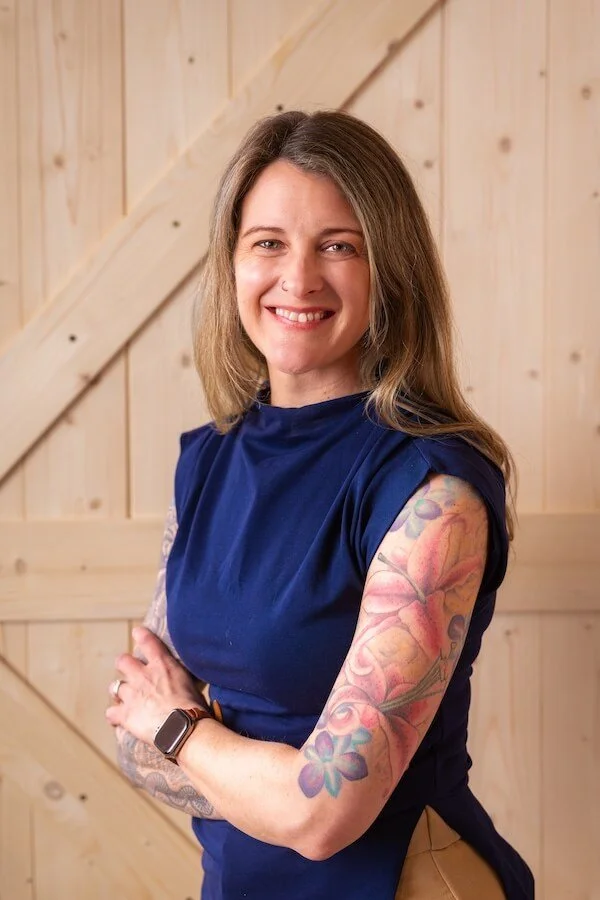 Psychiatry PA in Alaska smiling with tattooed arms crossed offering holistic whole body mental wellbeing for sustainable health