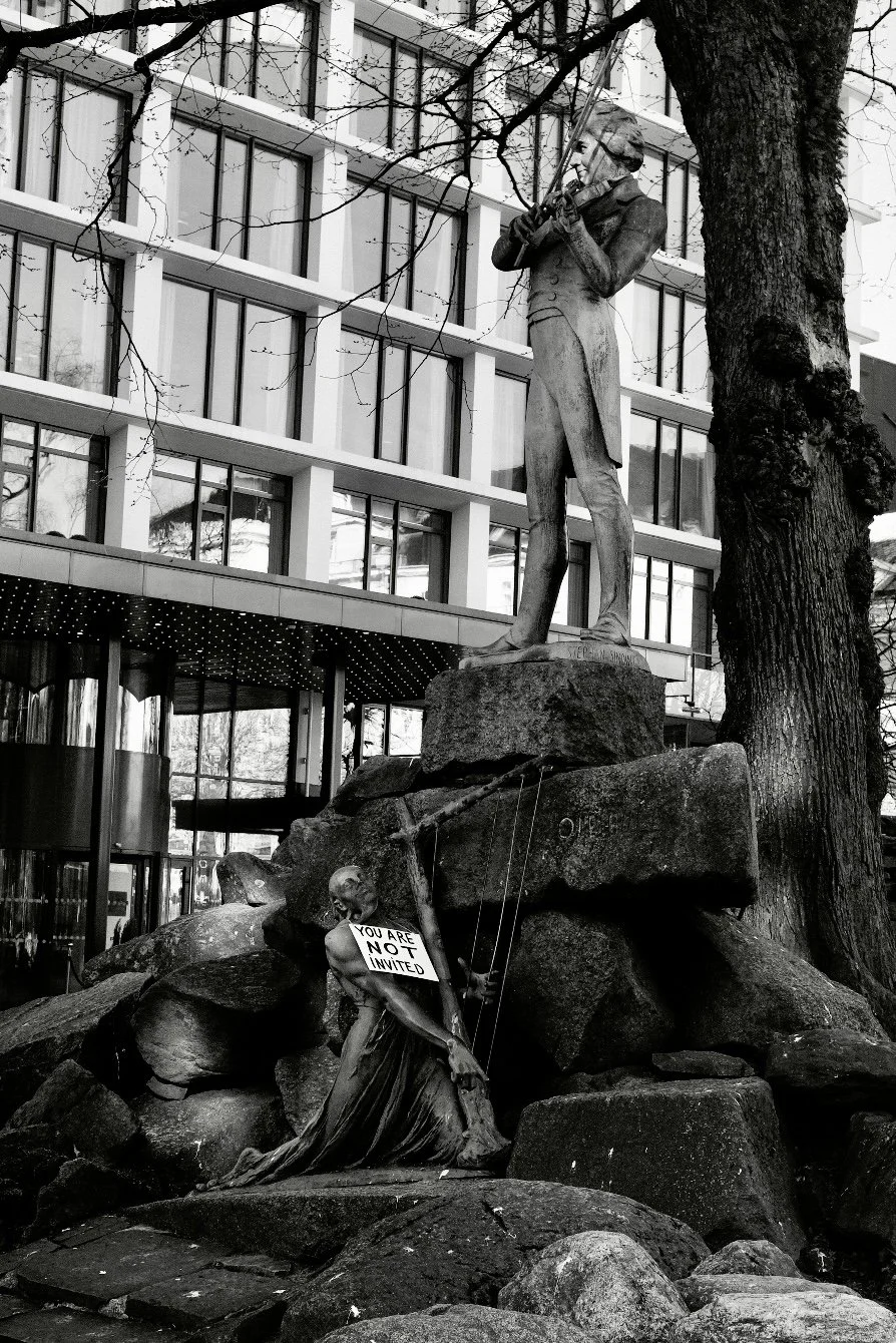 Street photography a Bergen, statua classica in bianco e nero con cartello you are not invited, reportage urbano Norvegia.