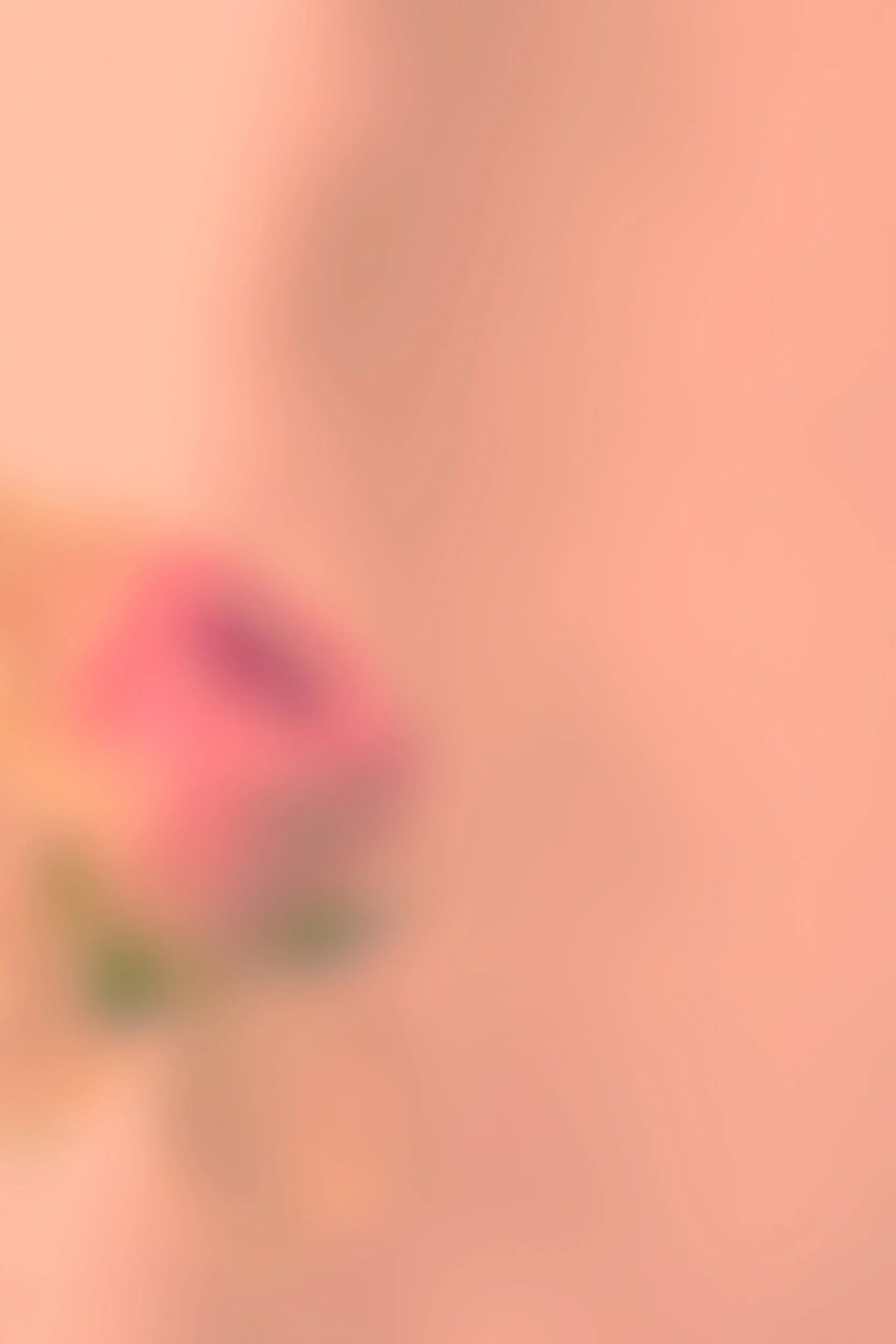 Ein unscharfes Bild mit einem rosa Hintergrund und einigen vagen Formen, die nicht klar erkennbar sind.