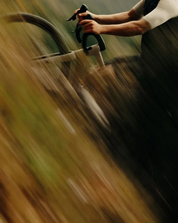 Someone riding a bicycle with motion blur in an outdoor setting.