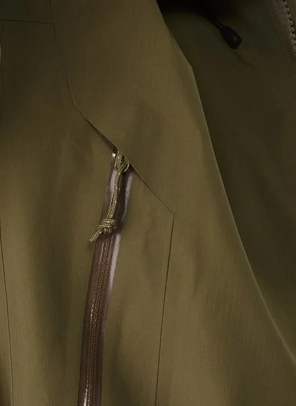 Close-up of a khaki uniform or jacket with a brown leather strap hanging from a metal zipper.