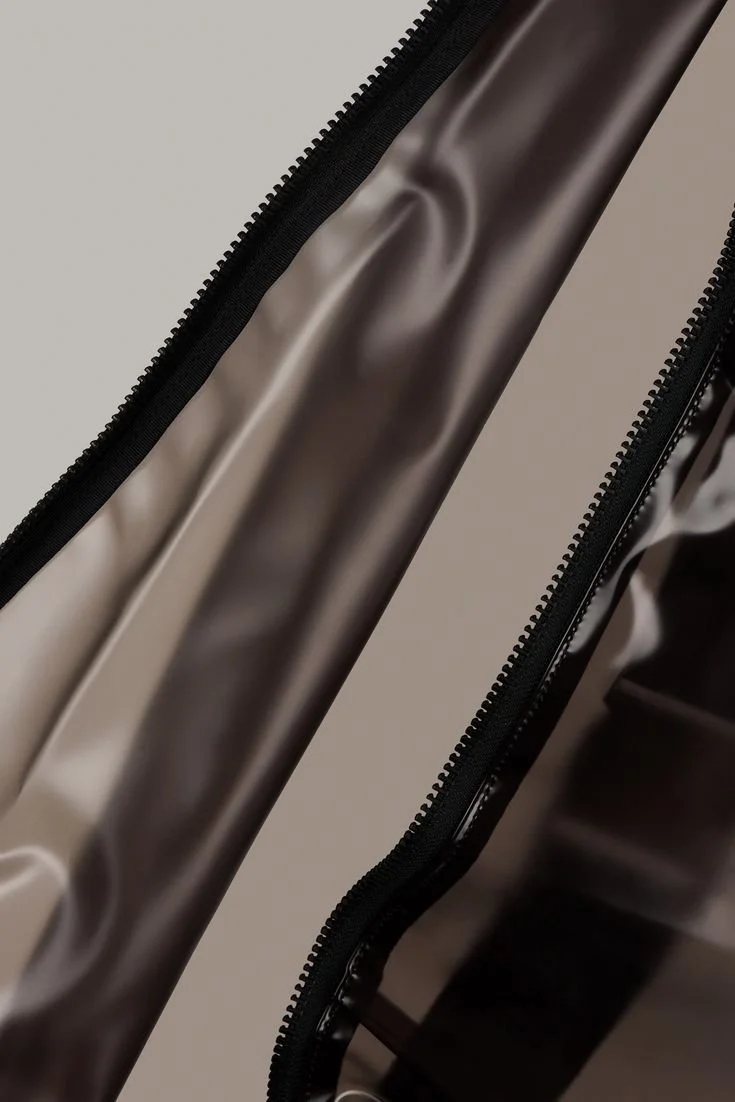 Close-up of a metallic-colored zipper on a shiny fabric surface.