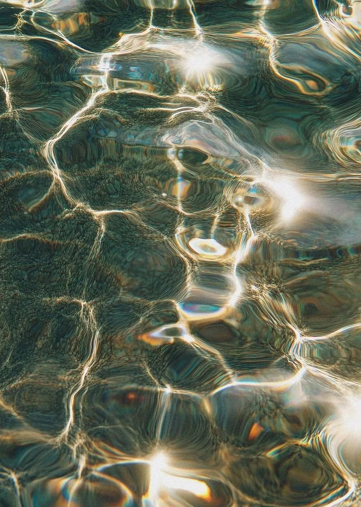 Sunlight reflecting off a calm body of water creating ripples and glimmering patterns.