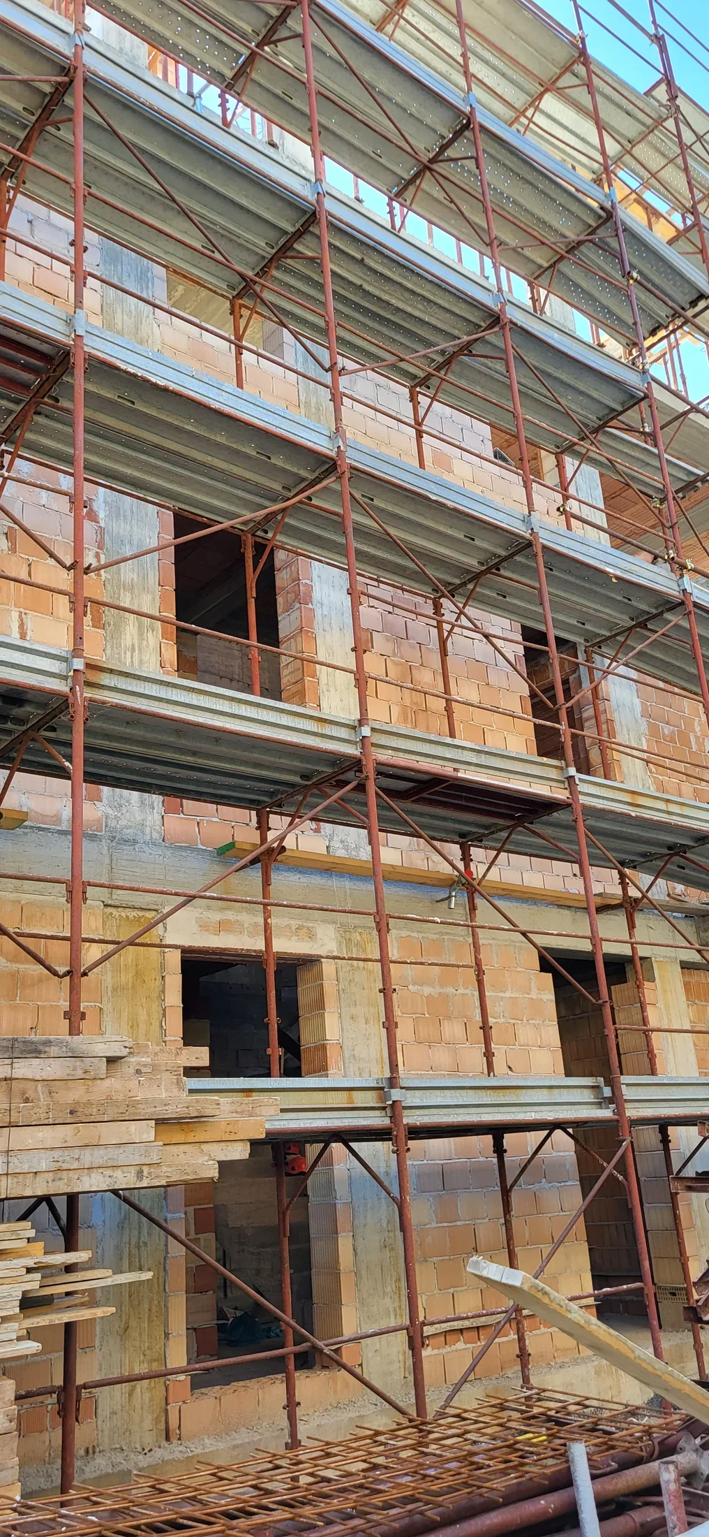Edificio in costruzione con murature, struttura in cemento armato e ponteggi: fotografia di cantiere Delta.