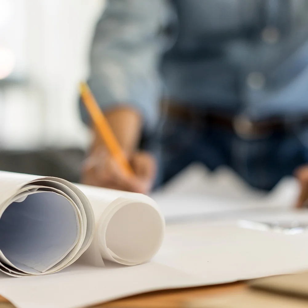 person writing on architectural drawings_shutterstock_423783703 web optimized.jpg