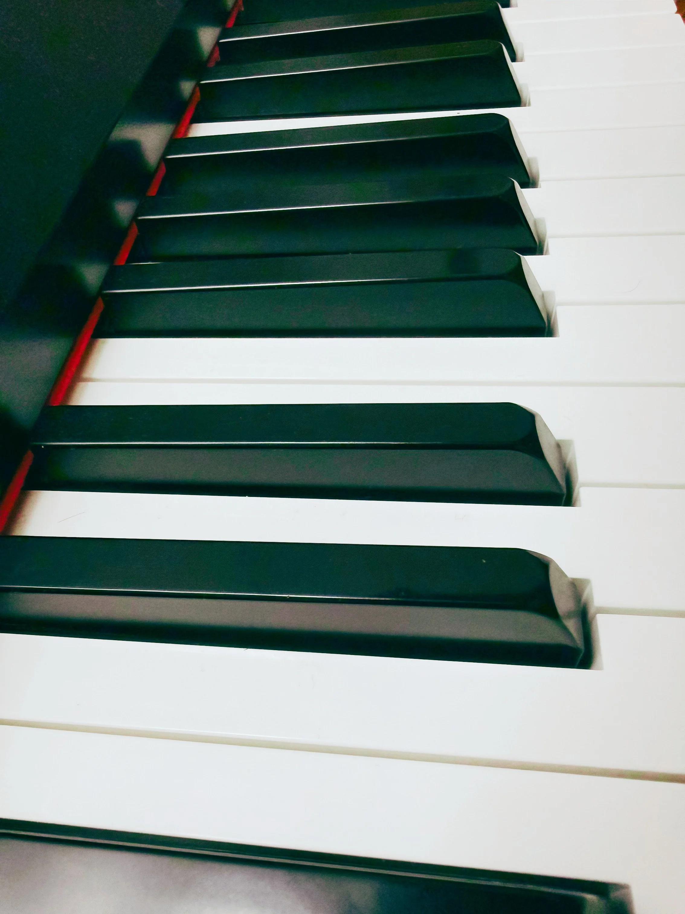 A close-up view of piano keys, showing alternating black and white keys.