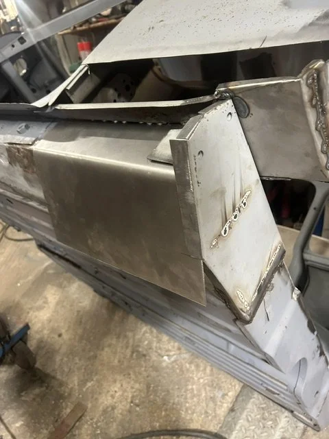 Close-up of metal aircraft or vehicle fuselage with visible welding and construction details.